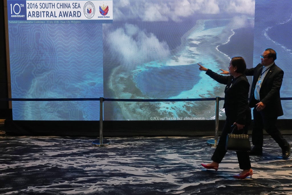 People pass by an electronic board showing areas of the disputed South China Sea during a conference in Manila on Friday to mark the 10th anniversary of a 2016 arbitration ruling which invalidated China’s expansive claims. Photo: AP