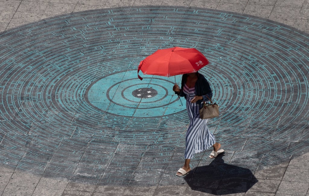 A woman uses an umbrella to shield herself from the sun in Frankfurt am Main, Germany, on Friday. Photo: EPA
