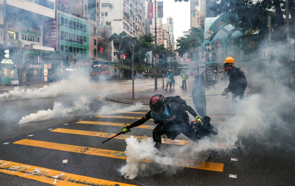 Anti-government protesters react to tear gas in Wan Chai following a rally in defiance of the anti-mask law issued by the government on October 5, 2019. Photo: Sam Tsang