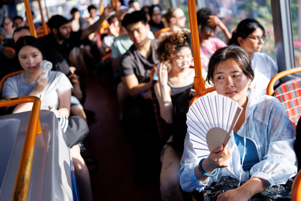 Passengers use fans to cool down on a TfL bus during a heatwave in East London on June 24. Photo: EPA