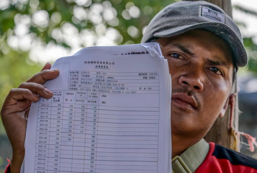 Akhmad, a former crew member of a Chinese fishing vessel, holds up his contract document indicating his monthly wages. Photo: AFP