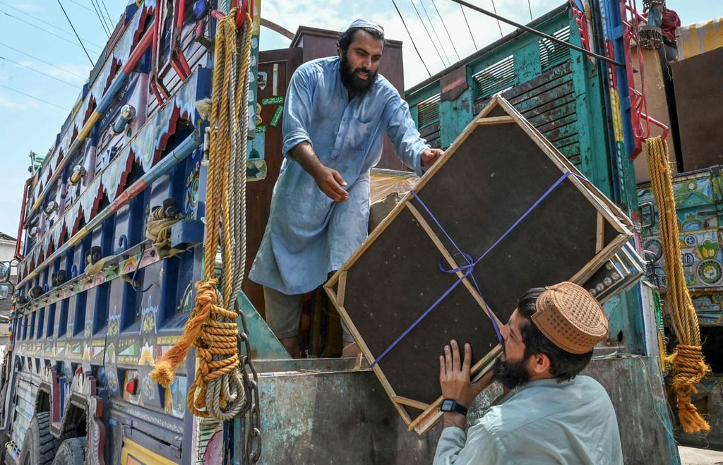 Men load their belongings onto a truck in Peshawar on Monday as they prepare to depart for Afghanistan. Photo: AFP