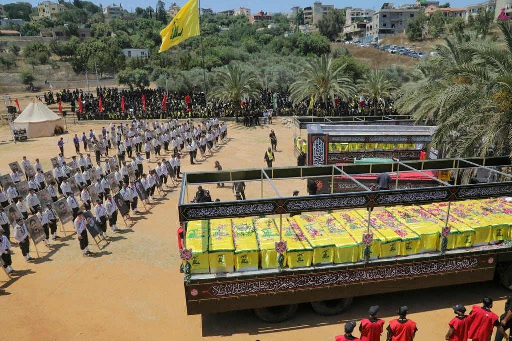 The caskets of Hezbollah fighters killed during clashes with the Israeli army are pictured to the right and left of a mock coffin of Iran’s slain supreme leader, Ayatollah Ali Khamenei, during a mass funeral in the southern Lebanese village of Majdel Selm on Saturday. Photo: AFP