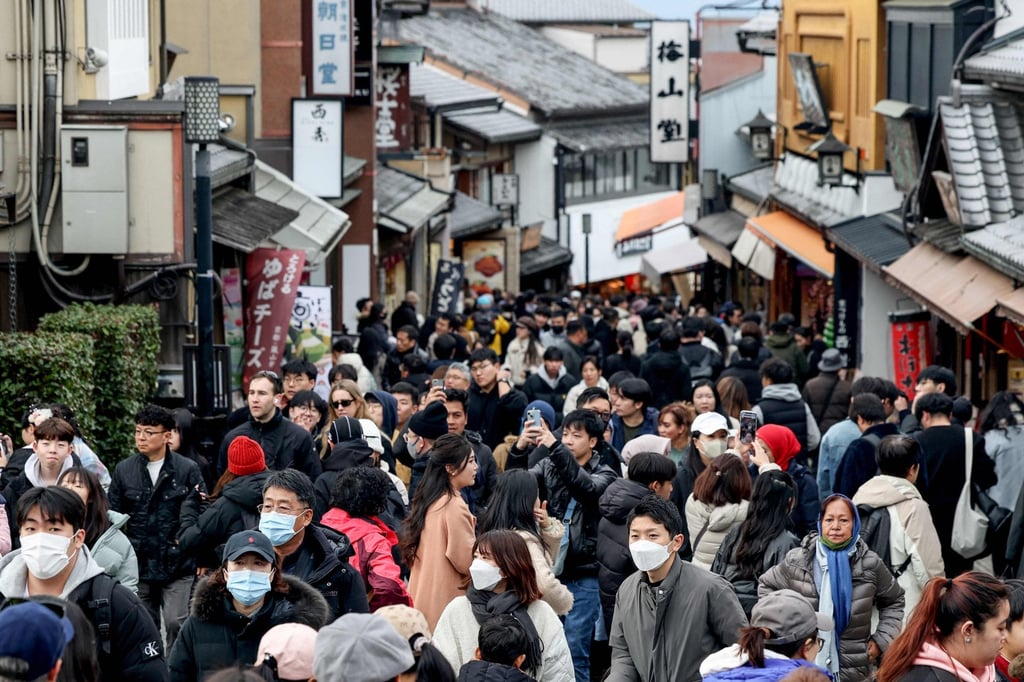 Tourists walk past shops and restaurants up the hill leading to Kiyomizu-dera temple in Kyoto in January 2025. Japan is targeting 60 million foreign tourists by 2030. Photo: AFP