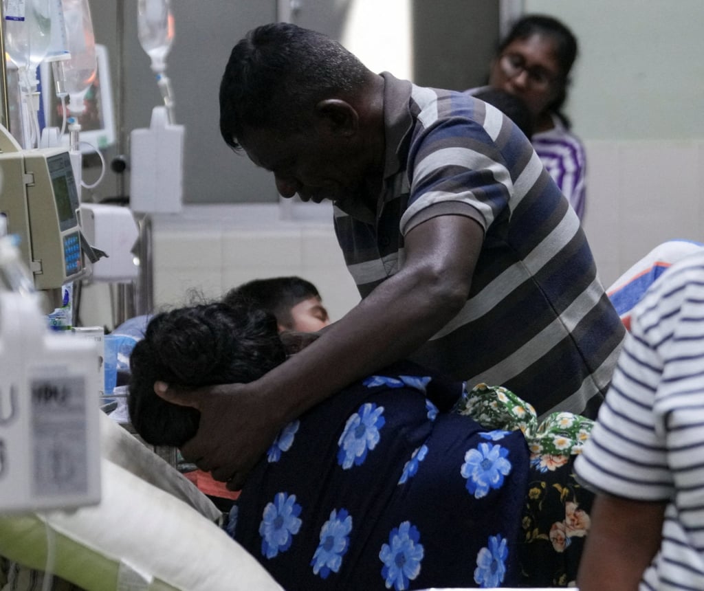 A dengue patient is assisted by a family member at the District General Hospital in Negombo, Sri Lanka, on Thursday. Photo: Reuters