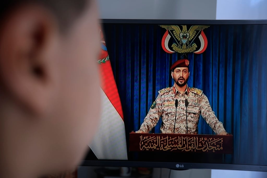 A person watches Houthi military spokesman Yahya Sarea deliver a televised statement in Sana’a, Yemen, on Monday. Photo EPA