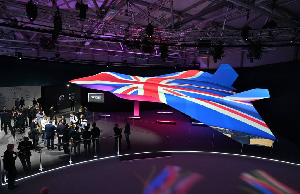 People view the Global Combat Air Programme’s 6th generation fighter jet concept design, bathed in the colours of the UK’s national flag, on the opening day of the Farnborough International Airshow, southwest of London, in 2024. Photo: AFP