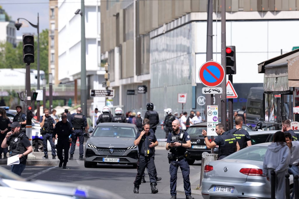 French police and rescuers walk down a street after a knife-wielding man wounded three people in Paris on Monday. Photo: AFP