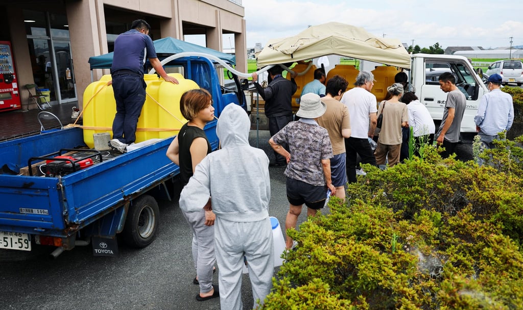 Local residents receive water aid due to a supply outage caused by Tuesday’s earthquake at a community centre in Yatsushiro on Thursday. Photo: Reuters