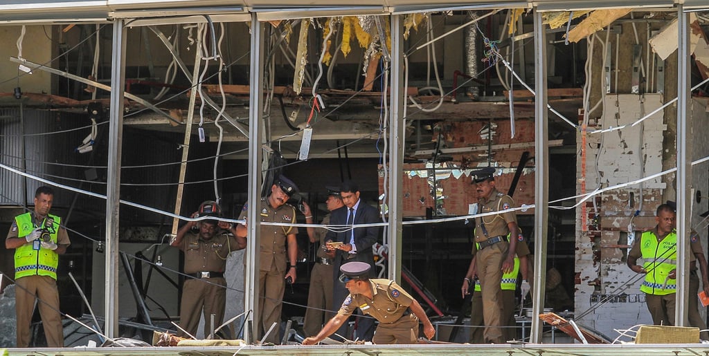 Sri Lankan police officers inspect the site of a fatal bombing at a hotel in Colombo in 2019. Photo: AP