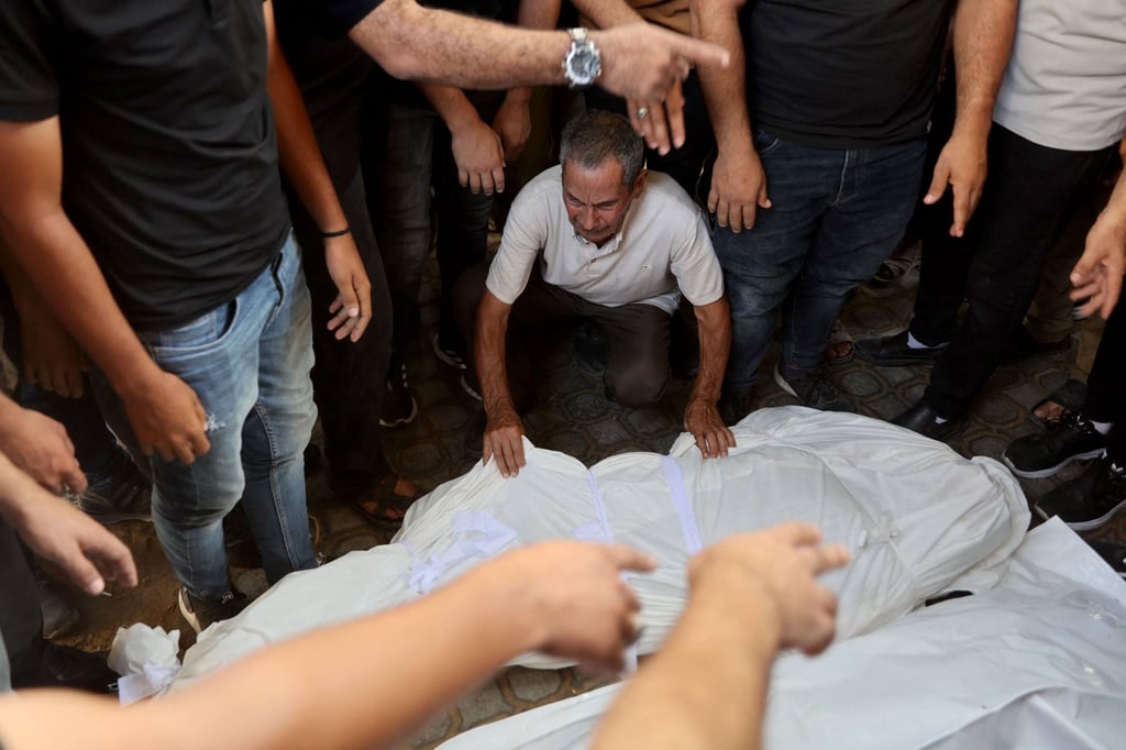 A man grieves over the body of a fellow Palestinian killed in an overnight Israeli air strike, at the al-Shifa Hospital in Gaza City on Sunday. Photo: AFP