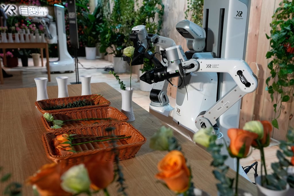 An XR robot places flowers into vases during a demonstration following X Square Robot’s introduction of the model, which can perform household tasks, in Beijing on April 21. Photo: AP