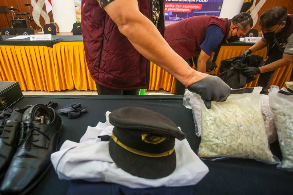 Indonesian Customs officials prepare to display the uniform of a Malaysian pilot and drugs he smuggled as evidence before a press conference at Soekarno-Hatta International Airport near Jakarta. Photo: AFP