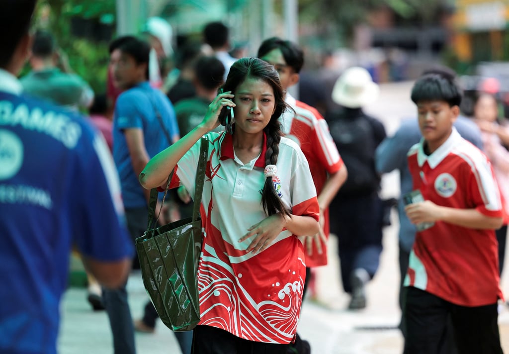 A student uses her mobile phone while walking at Debsirin Nonthaburi School on Friday. Photo: Reuters