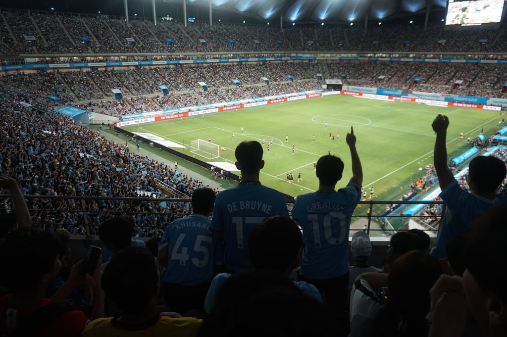 Fans decked in Manchester City jerseys celebrate after a goal during the club’s friendly match with Atletico Madrid at Seoul World Cup Stadium on Sunday. Photo: David D. Lee