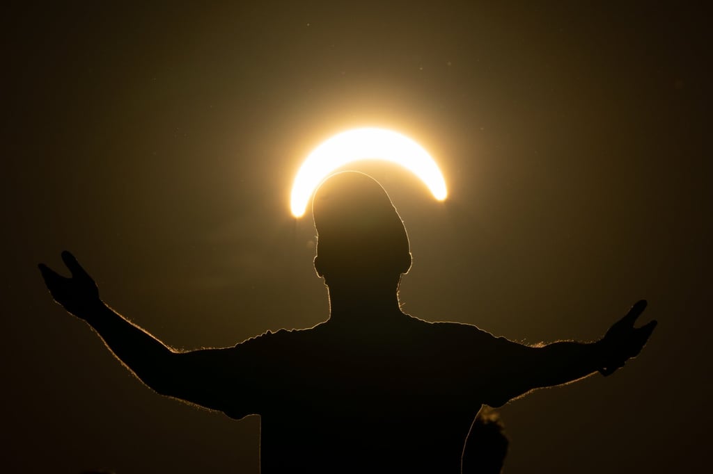 A man dances during a partial solar eclipse on top of Great Feldberg mountain northwest of Frankfurt, Germany, on Wednesday. Photo: EPA