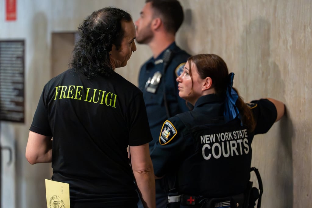 A man in a “Free Luigi” shirt speaks to a court officer during a pre-trial hearing in New York on Tuesday. Photo: EPA