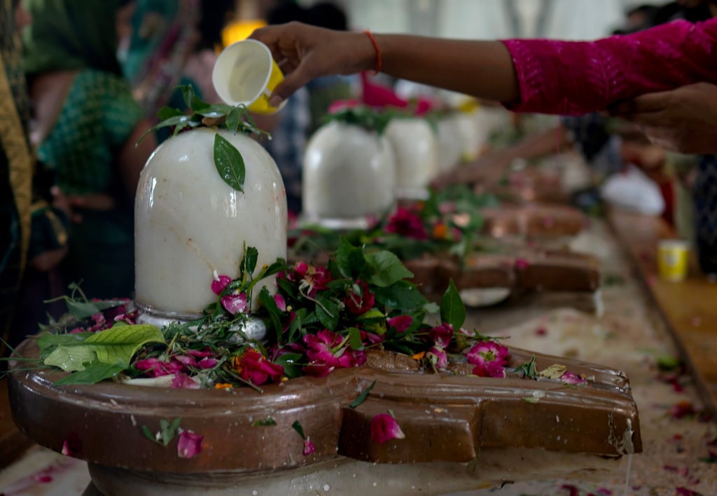 Devotees offer prayers at a row of Shivlings, idols symbolic of Hindu god Shiva at a temple in Prayagraj, Uttar Pradesh state, on August 10. Photo: AP
