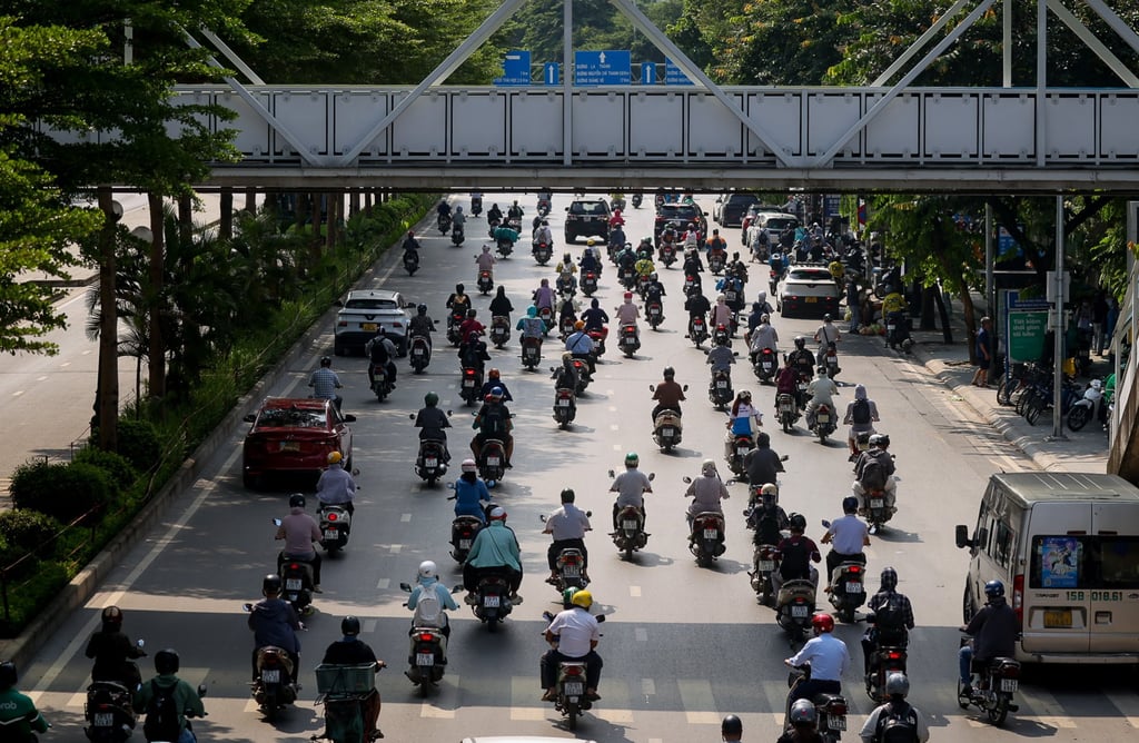 Motorists ride under scorching heat on a street in Hanoi, on August 10. Photo: EPA