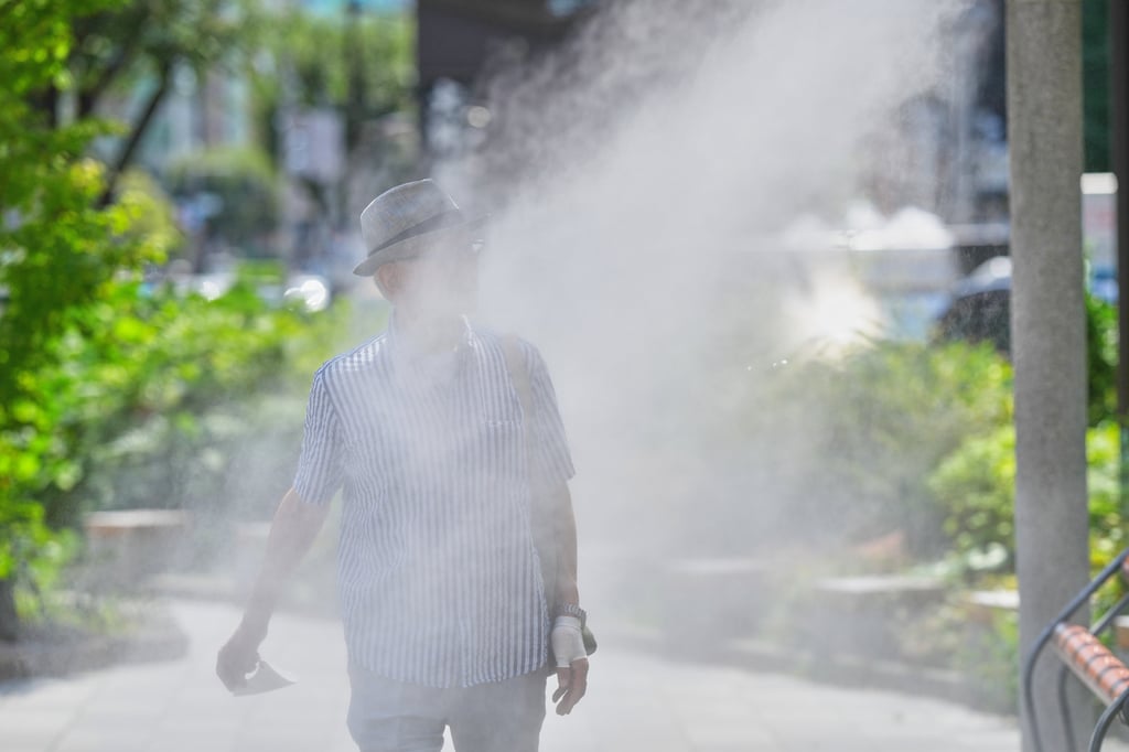 A person walks through mist from a cooling system on a hot day in Tokyo in August. Japan has been hit by one of its most severe heatwaves in recent years. Photo: AP