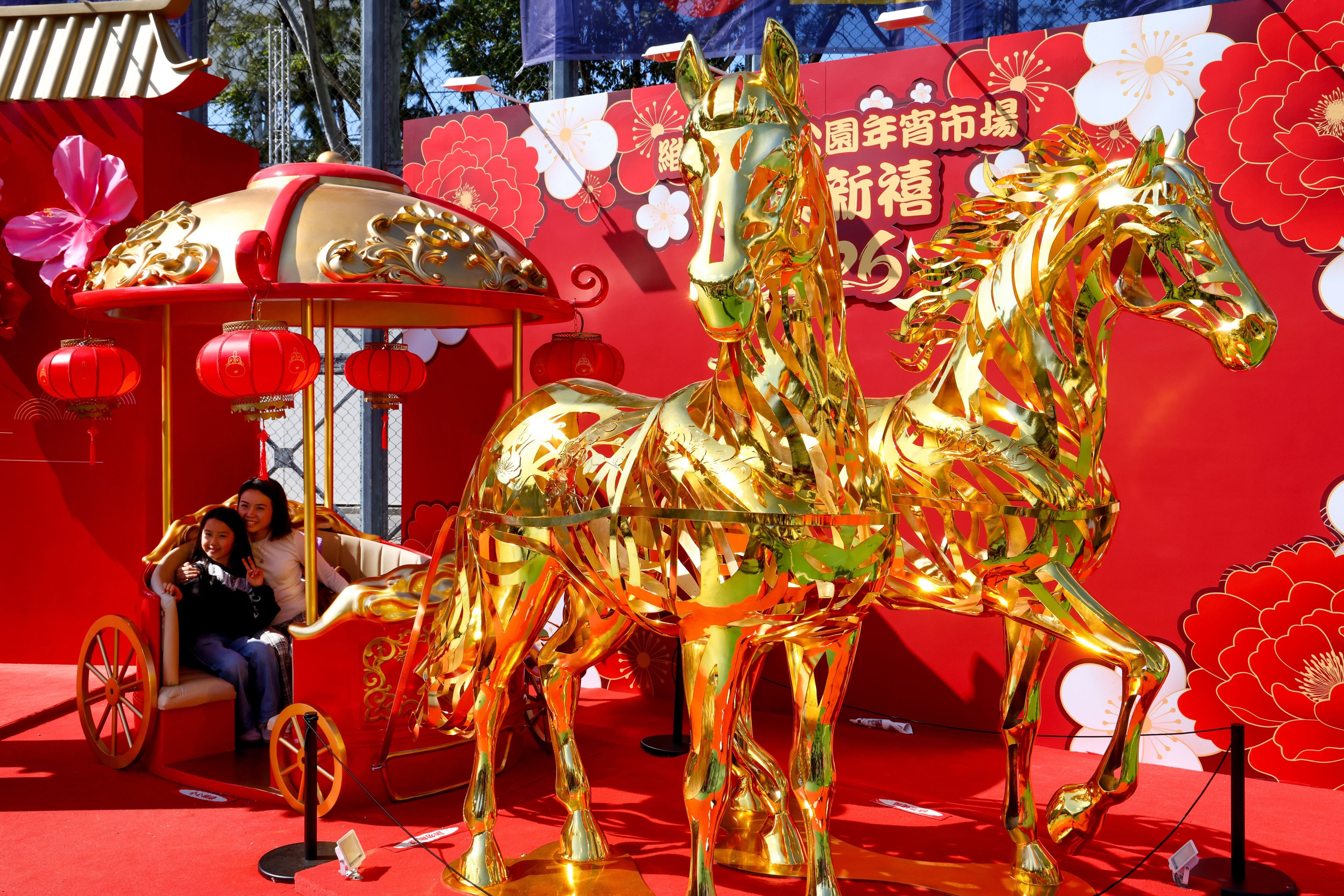 People shop for flowers, horse-themed goods and pose for pictures in the golden horse carriage decoration at Lunar New Year Flower Market and Fair held at the Victoria Park, Causeway Bay, on February 15. Photo: Dickson Lee