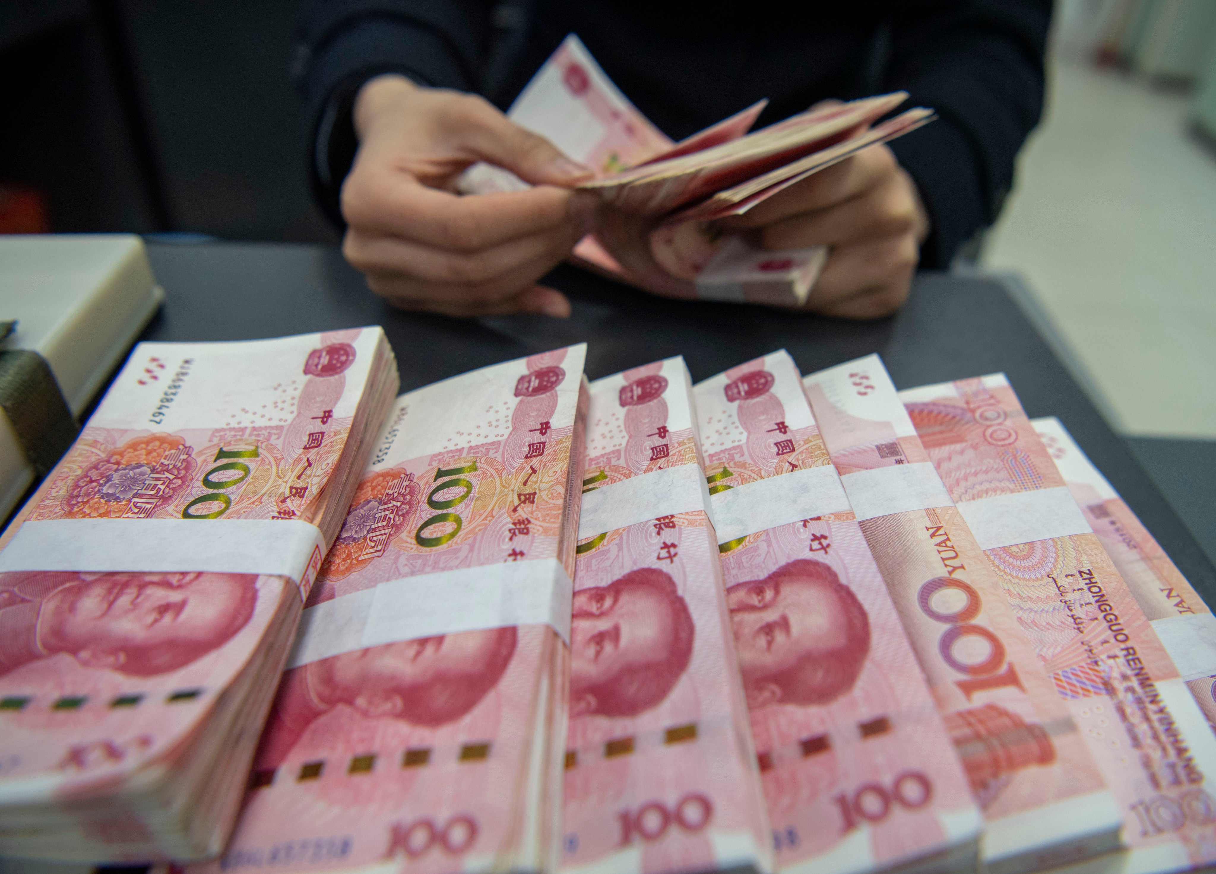 A bank teller counts yuan in Haian. Photo: CFOTO/Future Publishing via Getty Images