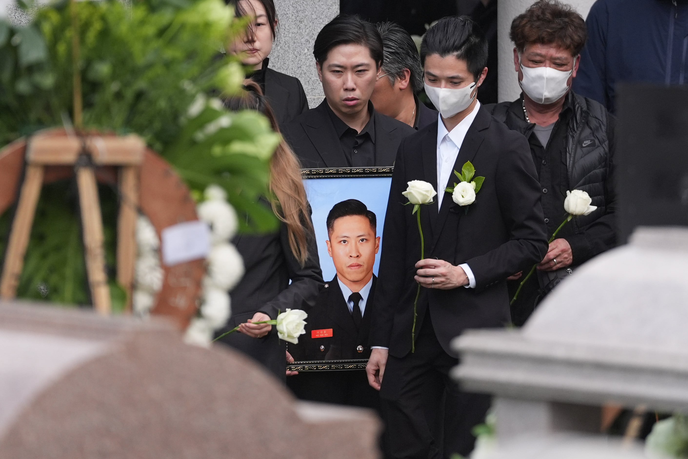 Family members, friends, colleagues and key officials bid farewell to firefighter Ho Wai-ho, who died battling the Tai Po blaze, at the cemetery in Gallant Garden in Fanling in December last year. Photo: Eugene Lee