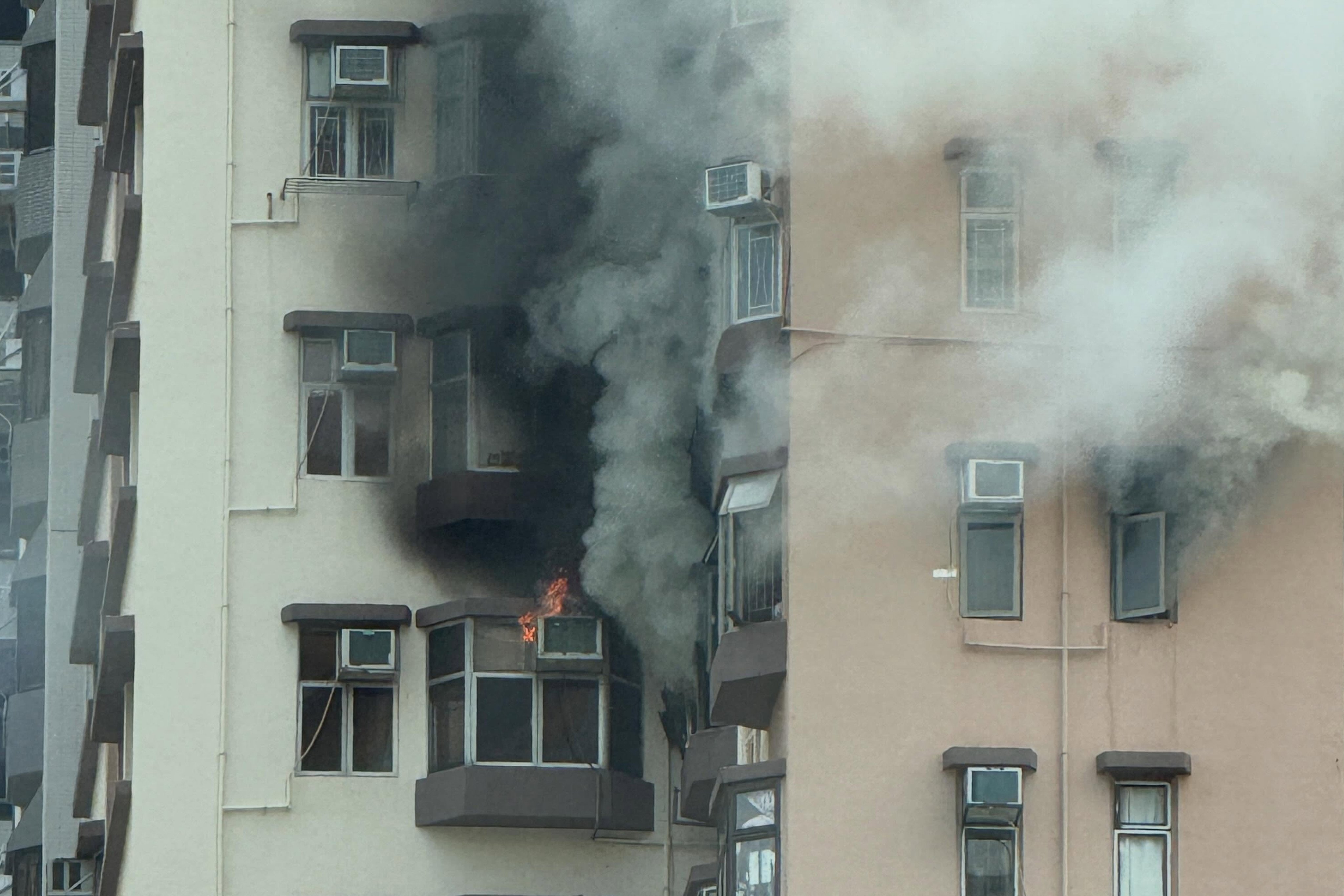 Smoking billows from a window at Valiant Court in Ho Man Tin. Photo: Threads