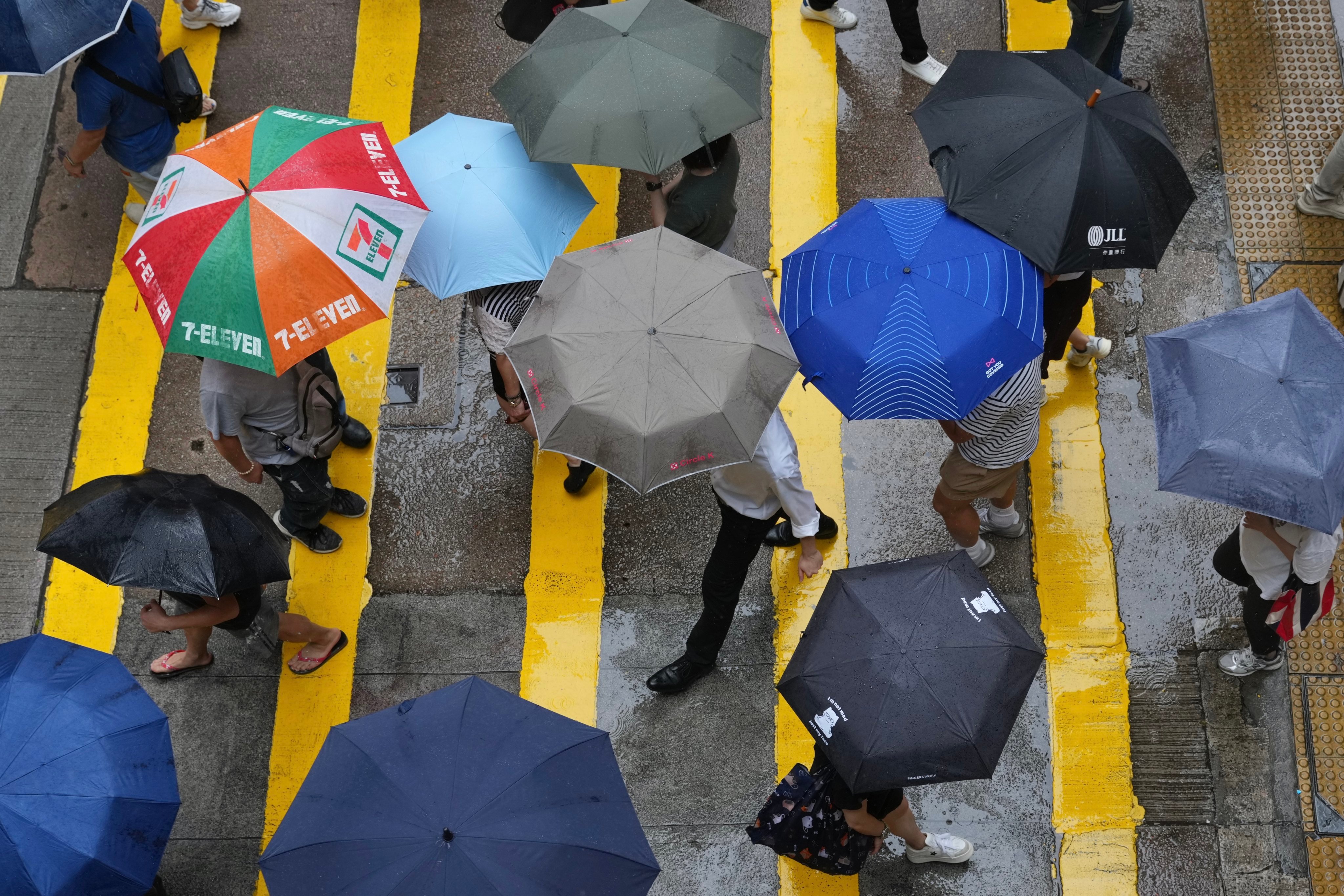 Pedestrians shelter under umbrellas in Wan Chai earlier this month. Photo: Karma Lo