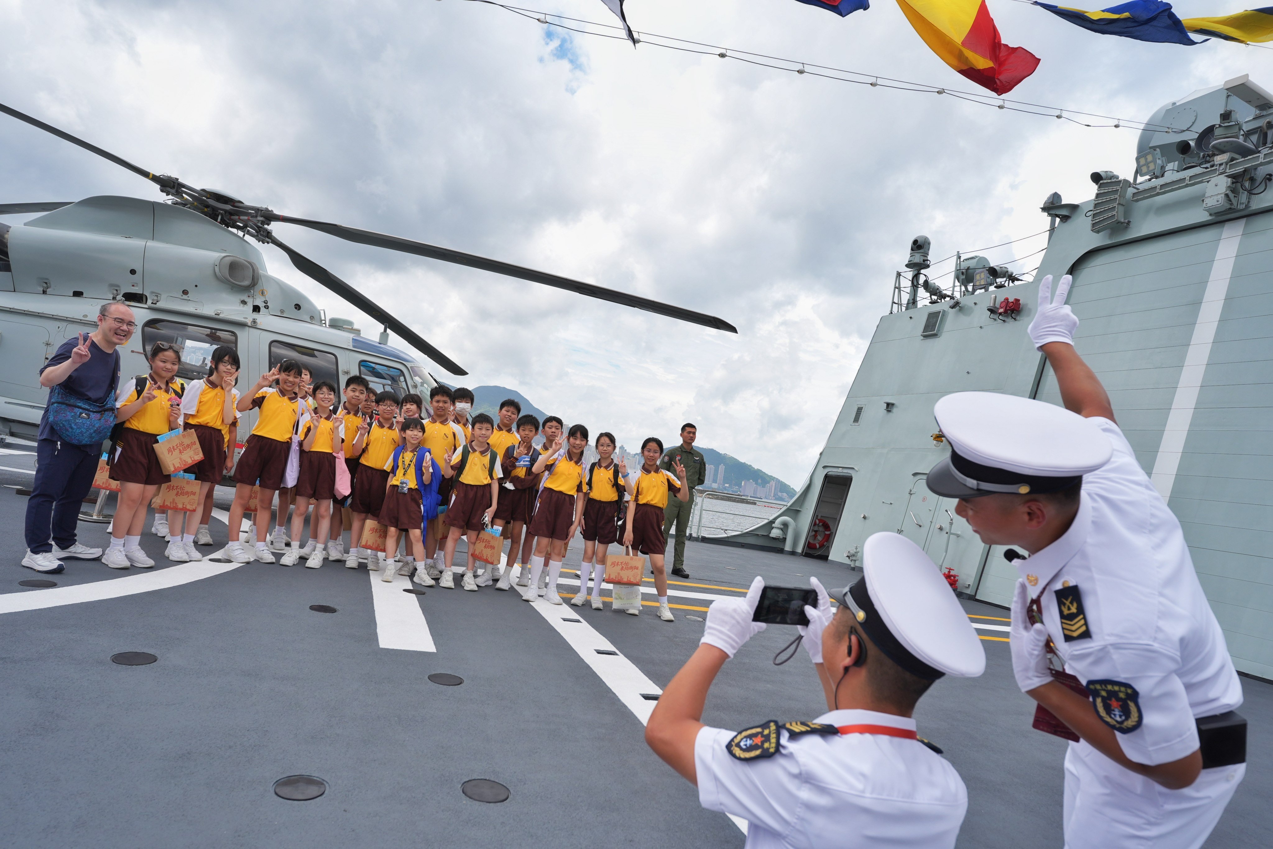PLA Navy officers take pictures for students during a tour. Photo: Elson Li