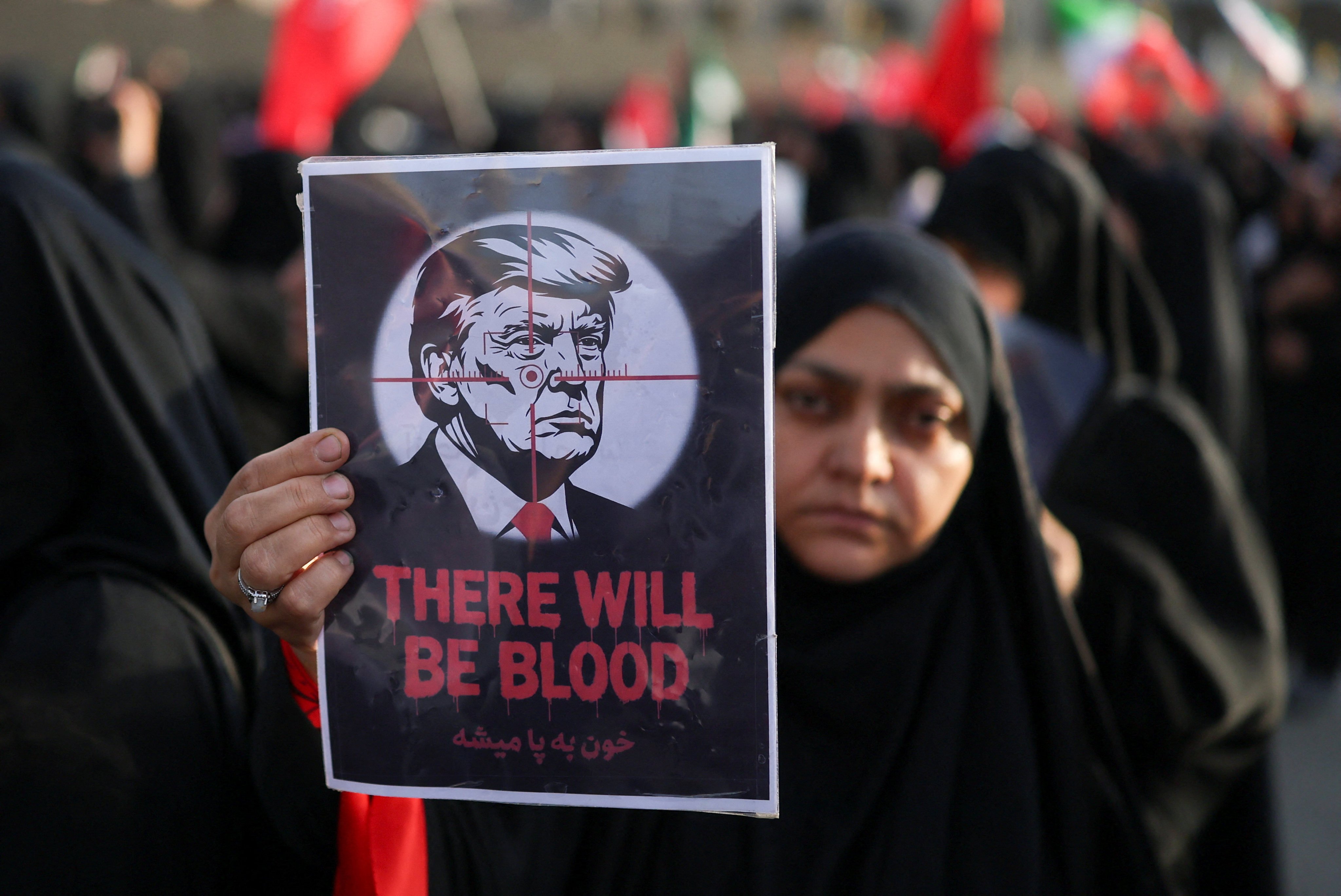 A woman holds a poster with an image of US President Donald Trump, on the day of a public farewell ceremony to pay respects to late supreme leader Ayatollah Ali Khamenei in Tehran on Saturday. Photo: Reuters