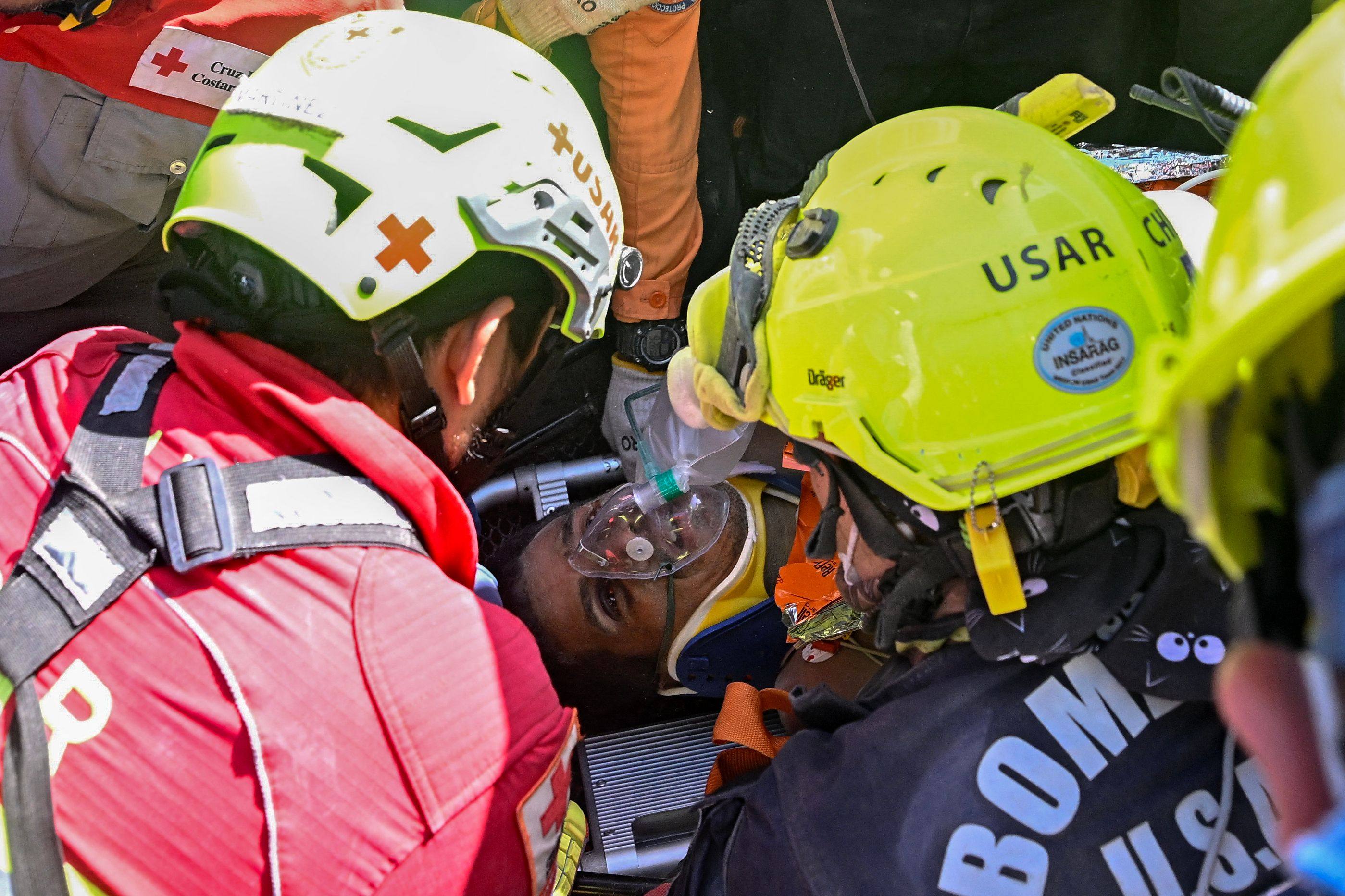 Hernan Gil after being pulled from the rubble. Photo: AFP