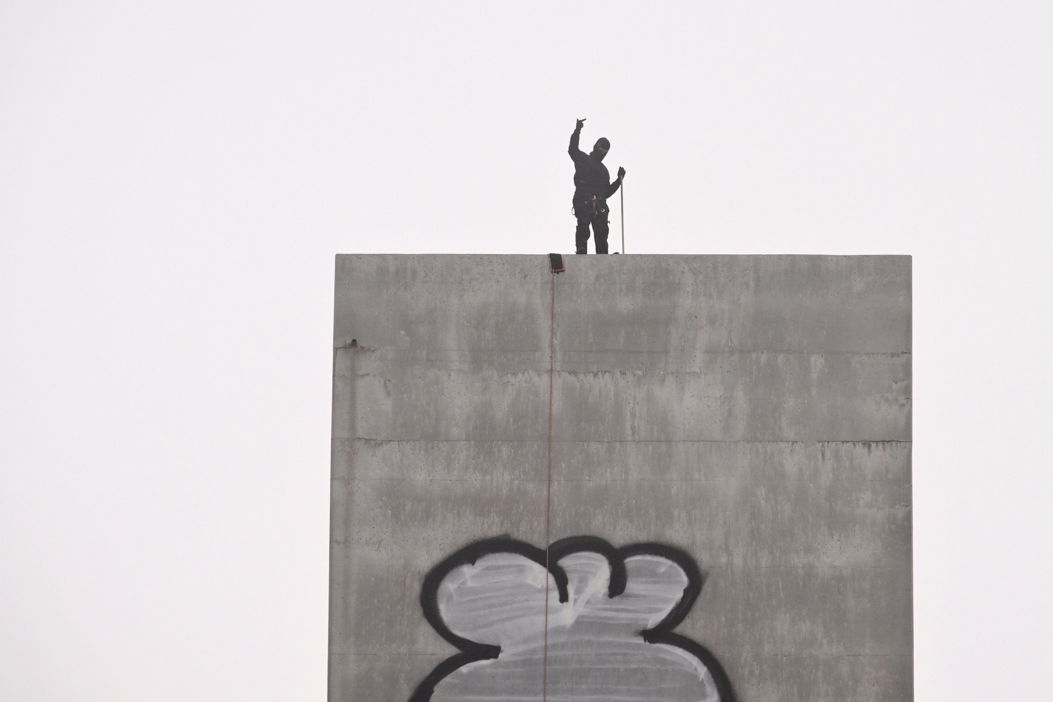 A man gestures from the top of the eastern pylon of the Bolte Bridge in Melbourne on Tuesday. Photo: EPA