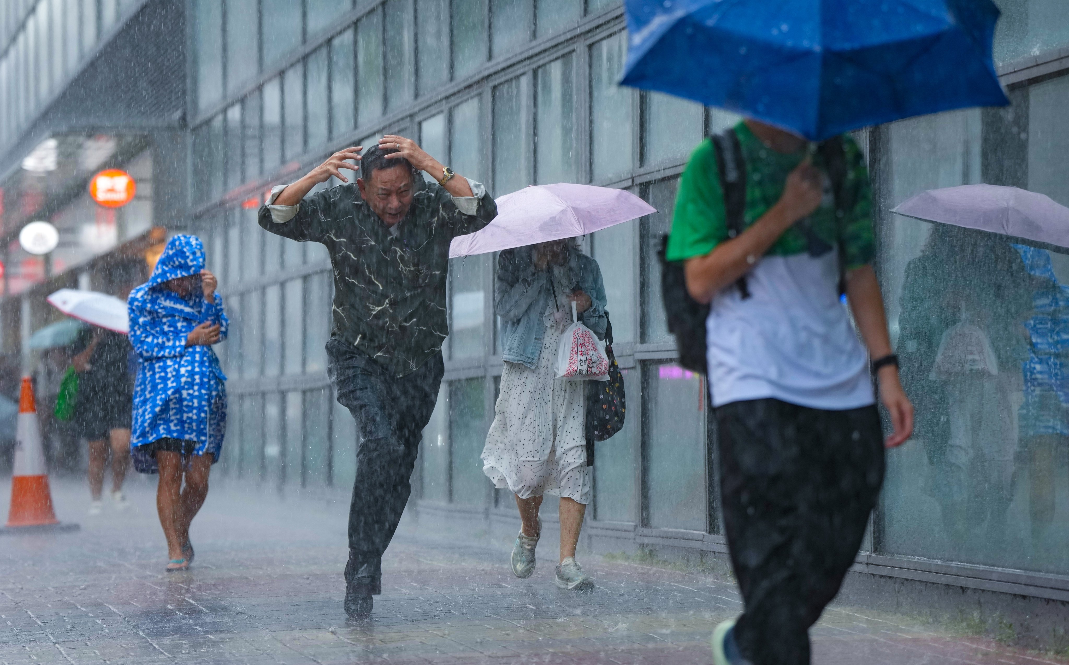 Pedestrians brave heavy rain in Tai Wai on Tuesday. Photo: Sam Tsang
