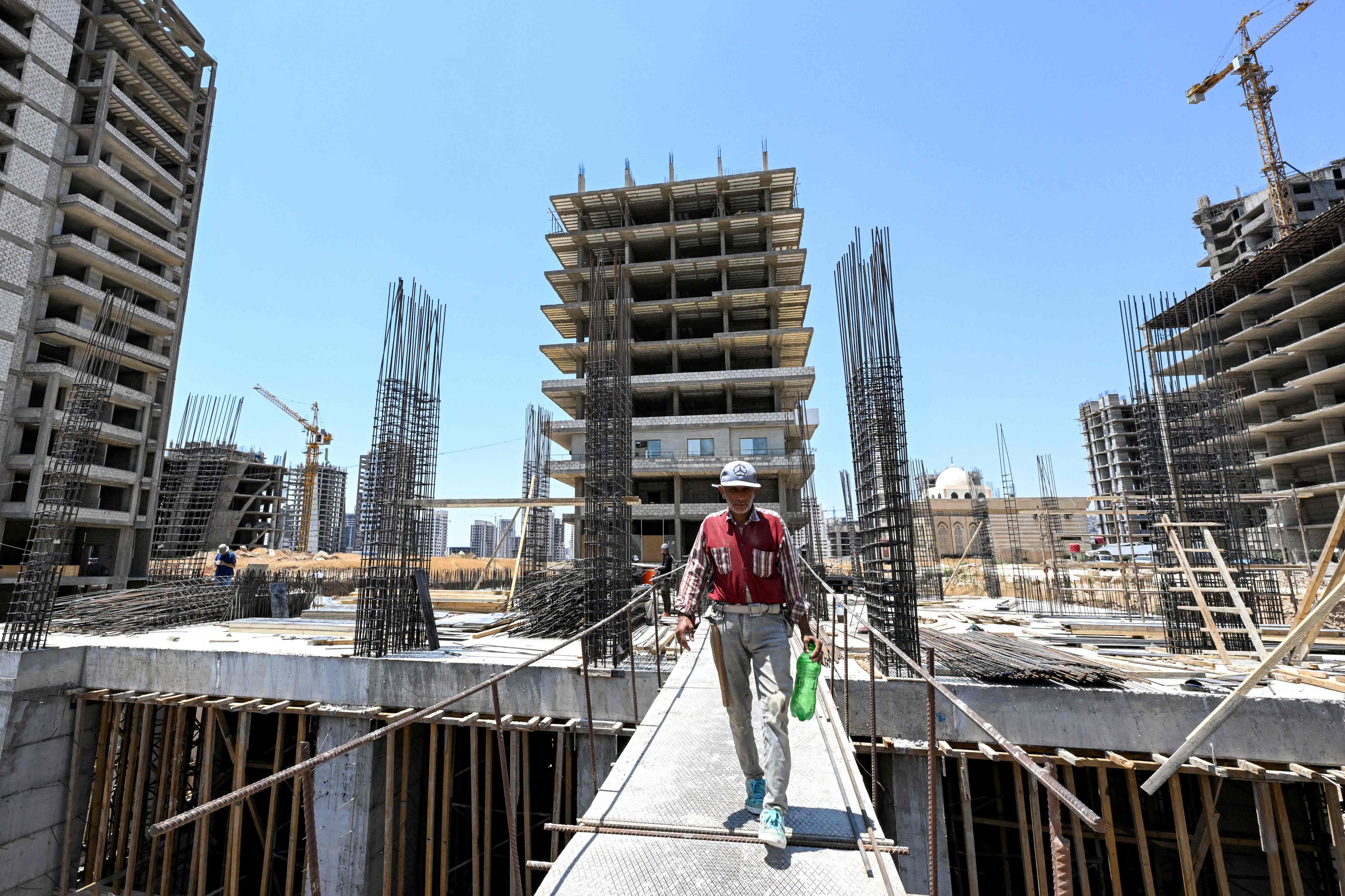 A worker walks through a construction site for a new mixed-use development project near Umayyad Square in Damascus, Syria. Photo: AFP