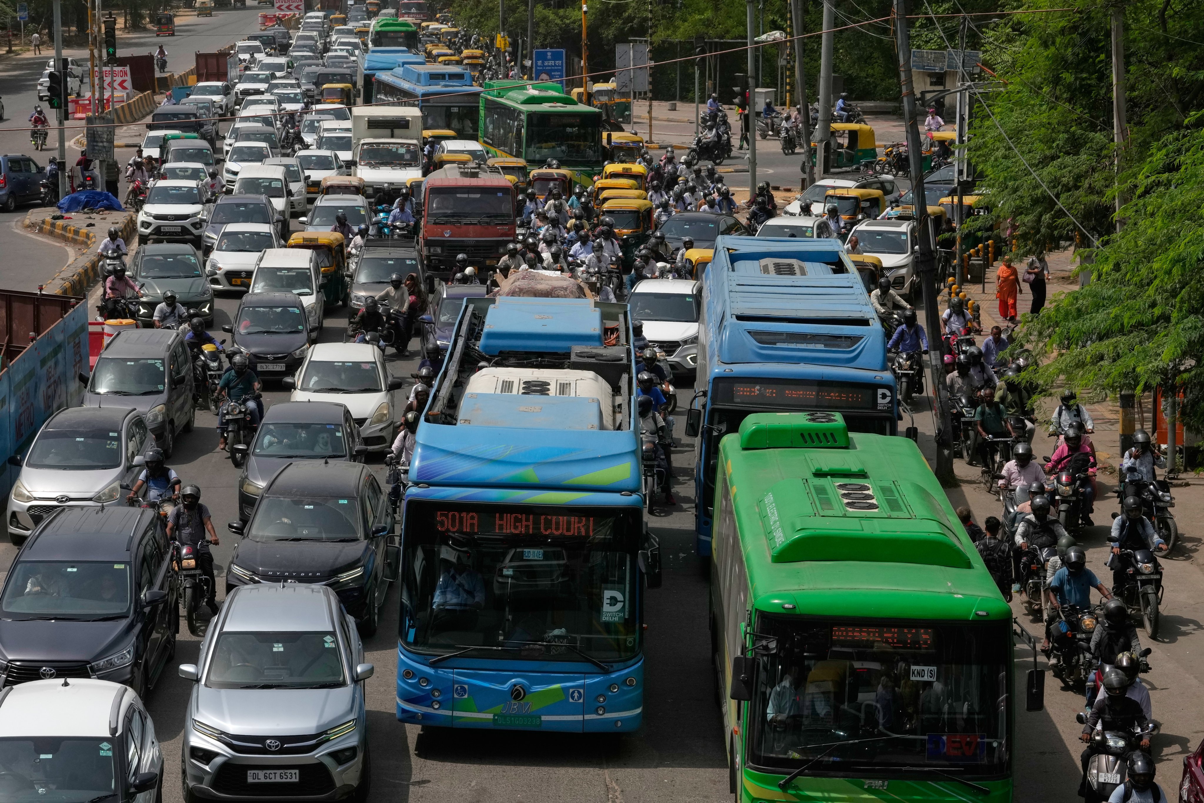 Electric buses move through dense traffic alongside other vehicles and scooters in Delhi on July 14. Photo: AP
