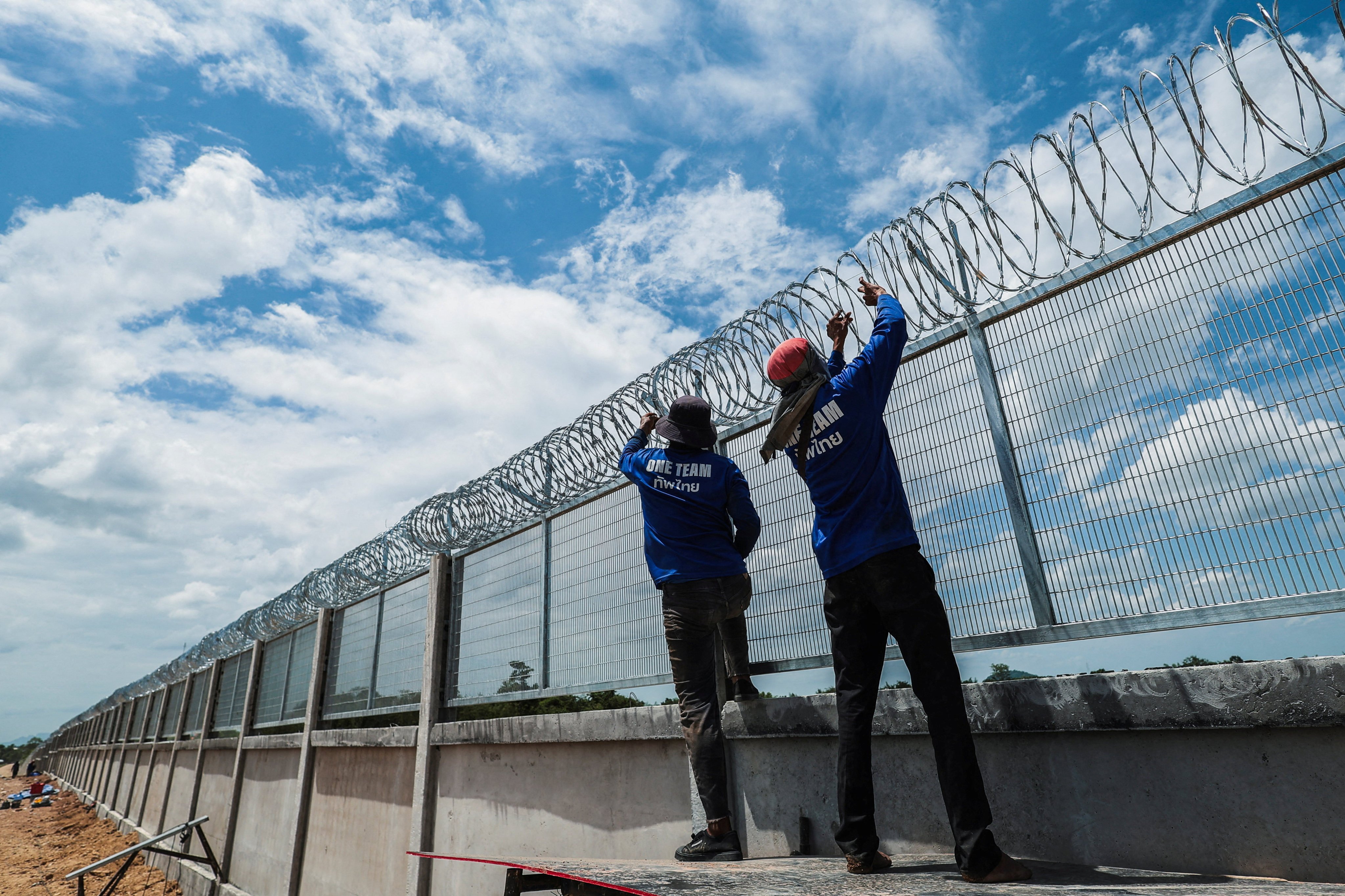 Workers install concertina wire on a section of the border fence between Thailand and Cambodia in Pong Nam Ron district, Chanthaburi province, on July 22. Photo: Reuters