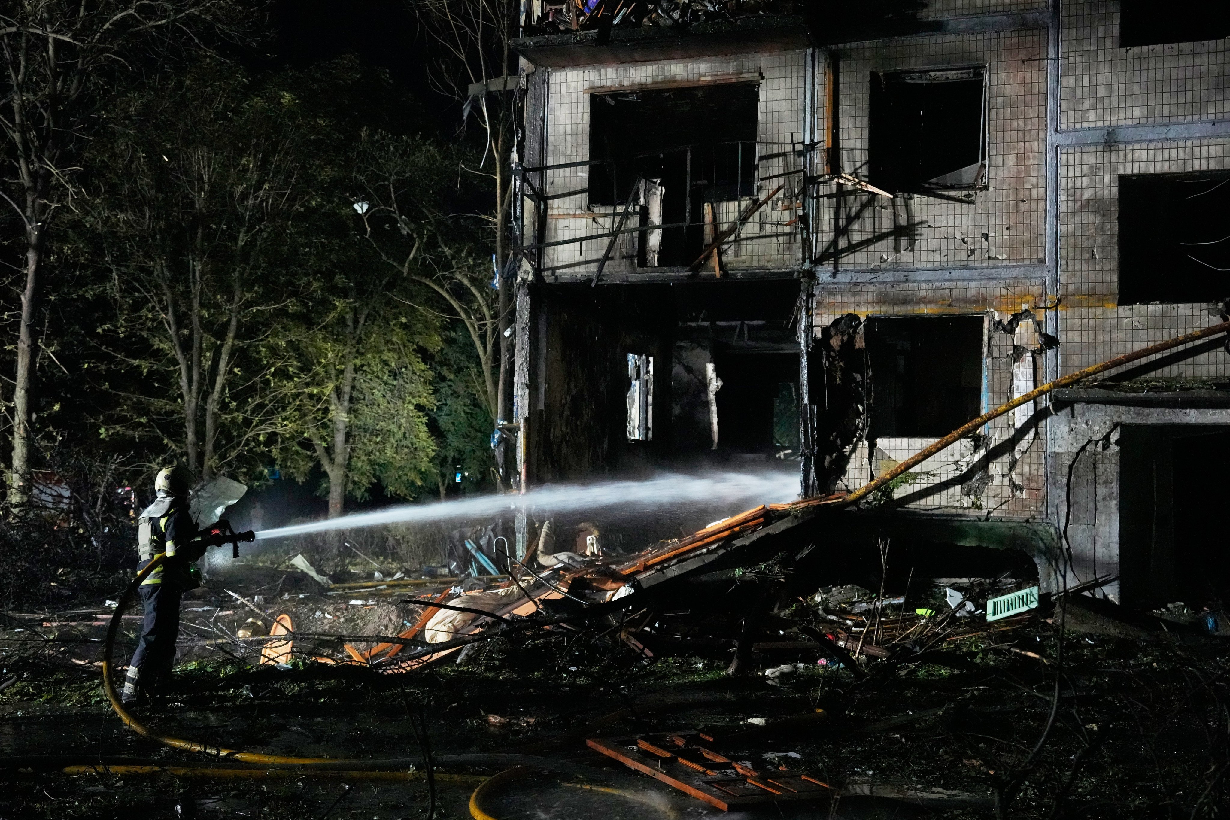 Emergency services personnel work to extinguish a fire following Russian missile attacks in Kyiv on Saturday. Photo: AP