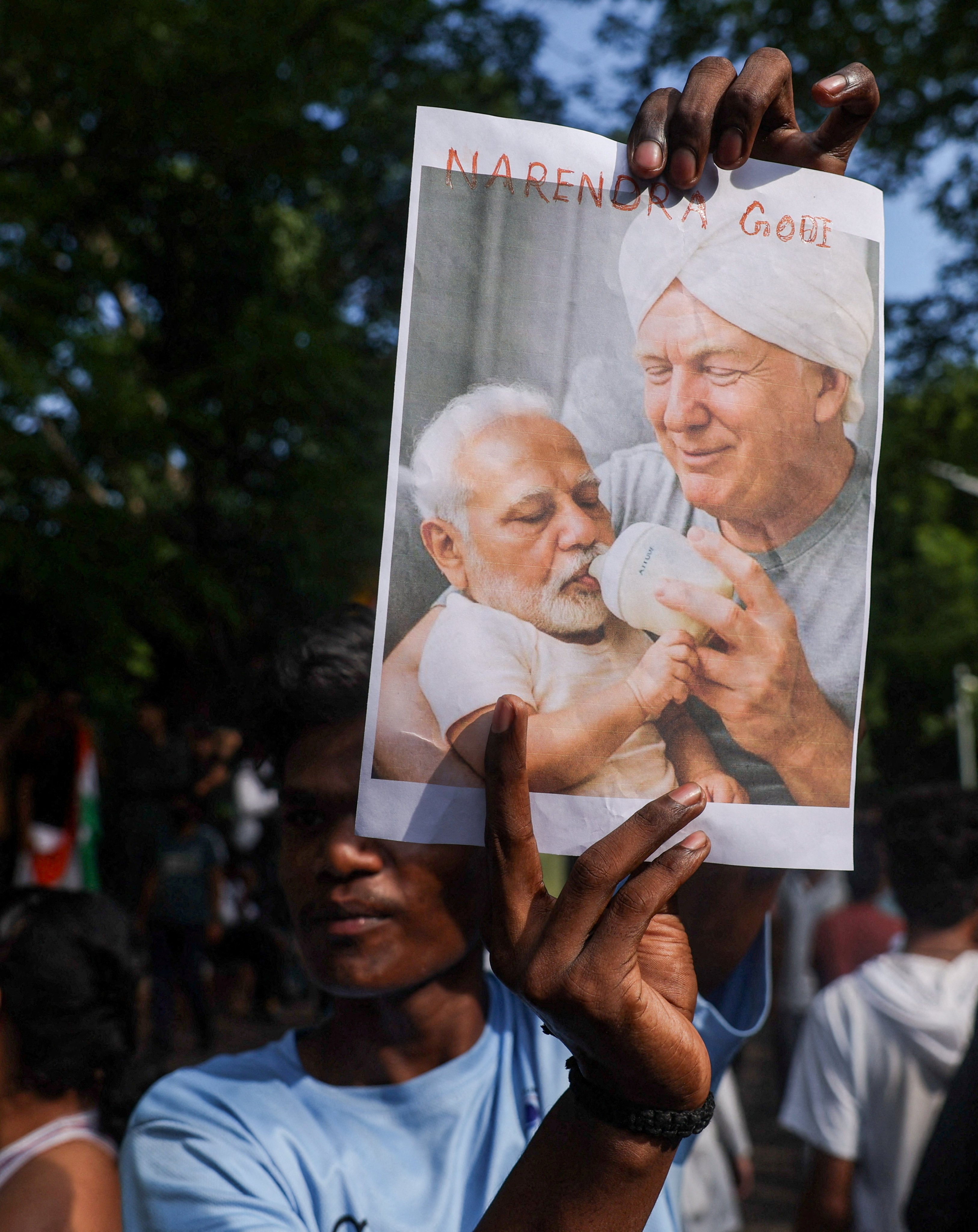 A man holds an image depicting US President Donald Trump and Indian Prime Minister Narendra Modi during a protest in New Delhi on July 24. Photo: Reuters