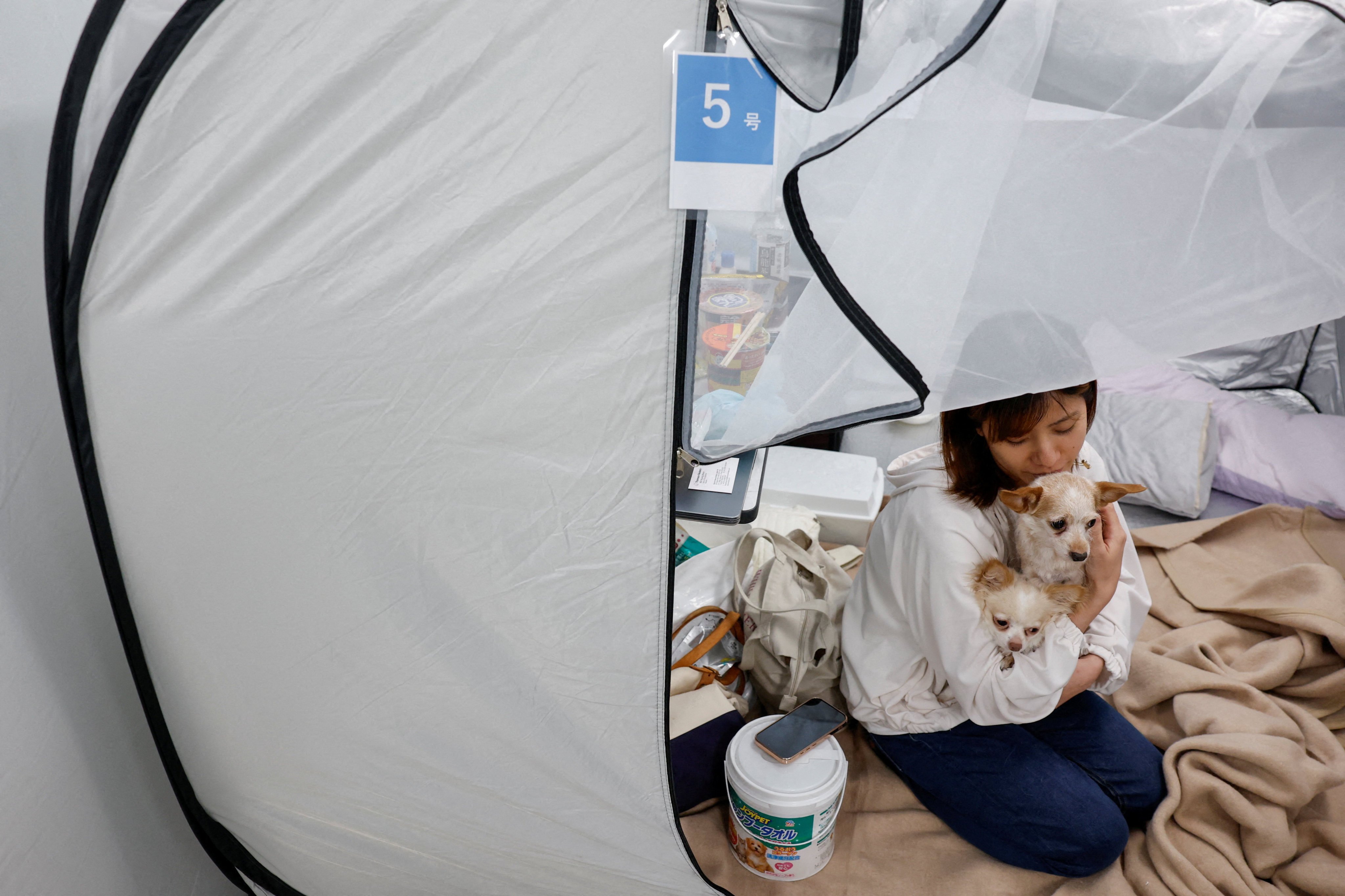 Tomoko Takaoka, who evacuated from Uki with her pets after Tuesday’s earthquake, sits in a tent in a shelter for evacuees with pets in Kumamoto, on Friday. Photo: Reuters