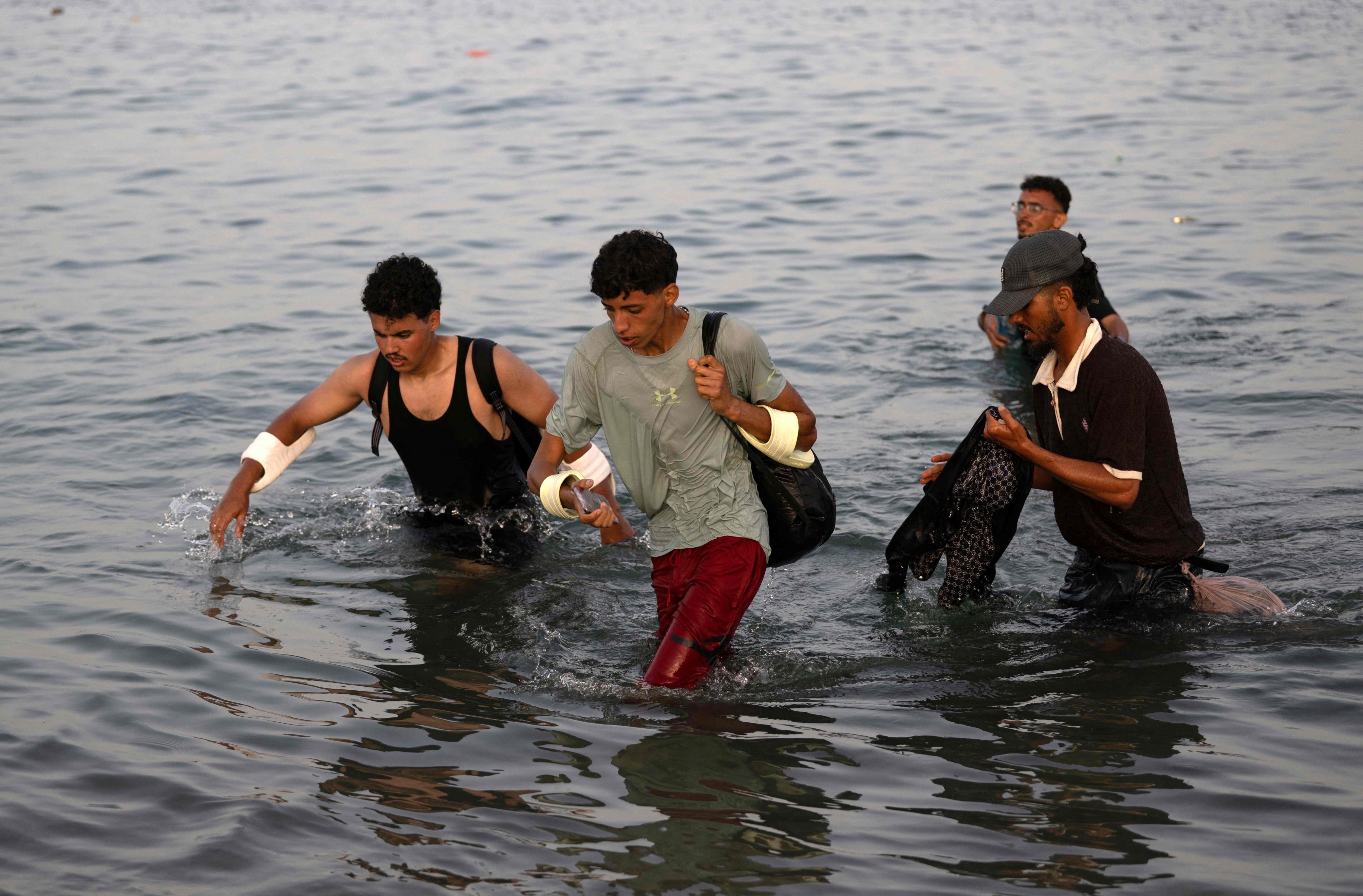 Migrants wade through the water near the border with Morocco as they attempt to enter Spain’s North African enclave of Ceuta on Friday. Photo: AFP