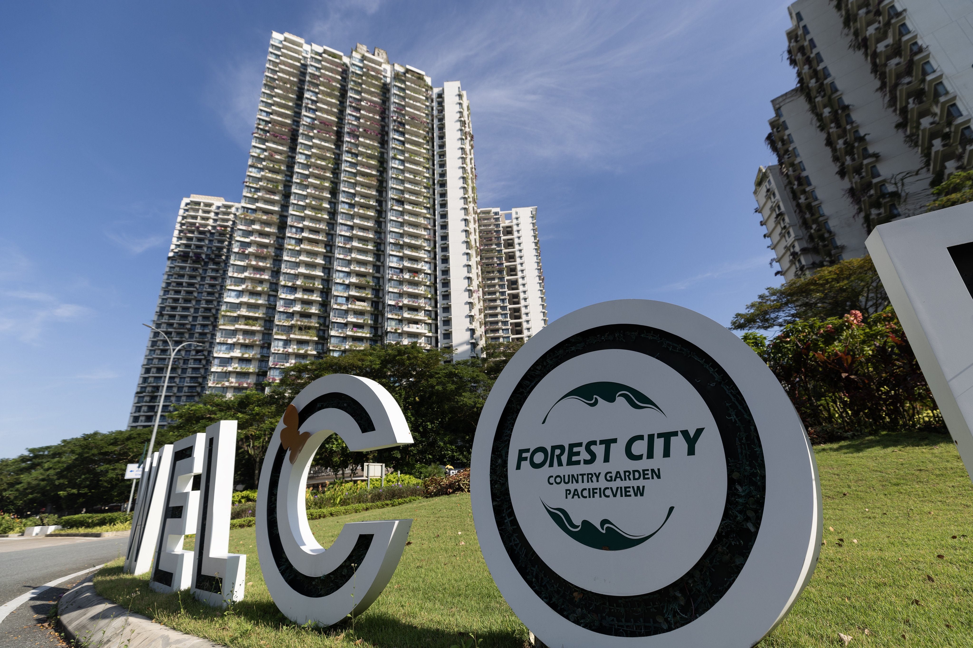 A welcome sign stands at a roundabout in front of residential buildings in Forest City in Johor Bahru, Malaysia, in December 2023. Photo: EPA-EFE