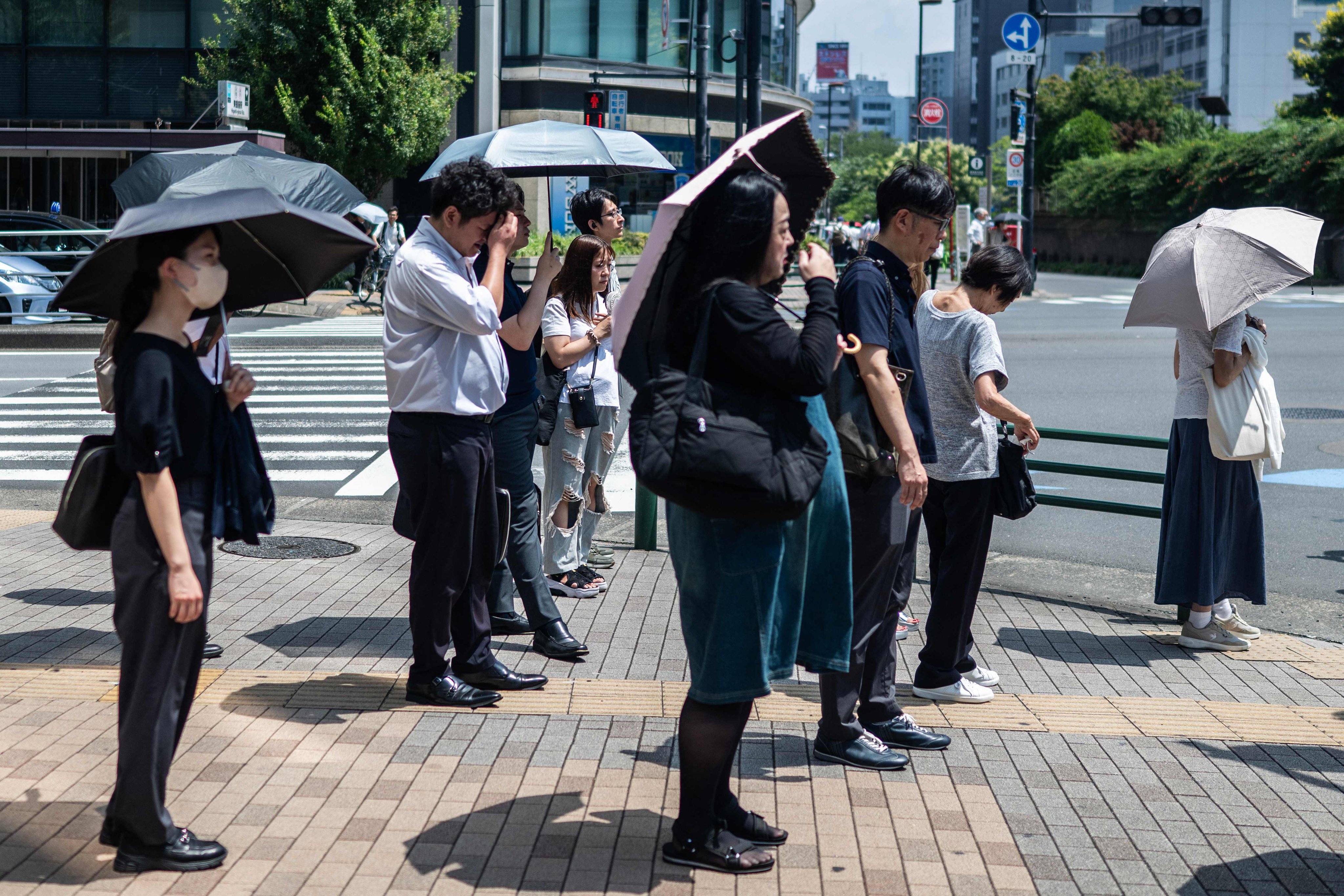 People carry umbrellas to shelter from the sun in Tokyo last month. Photo: AFP