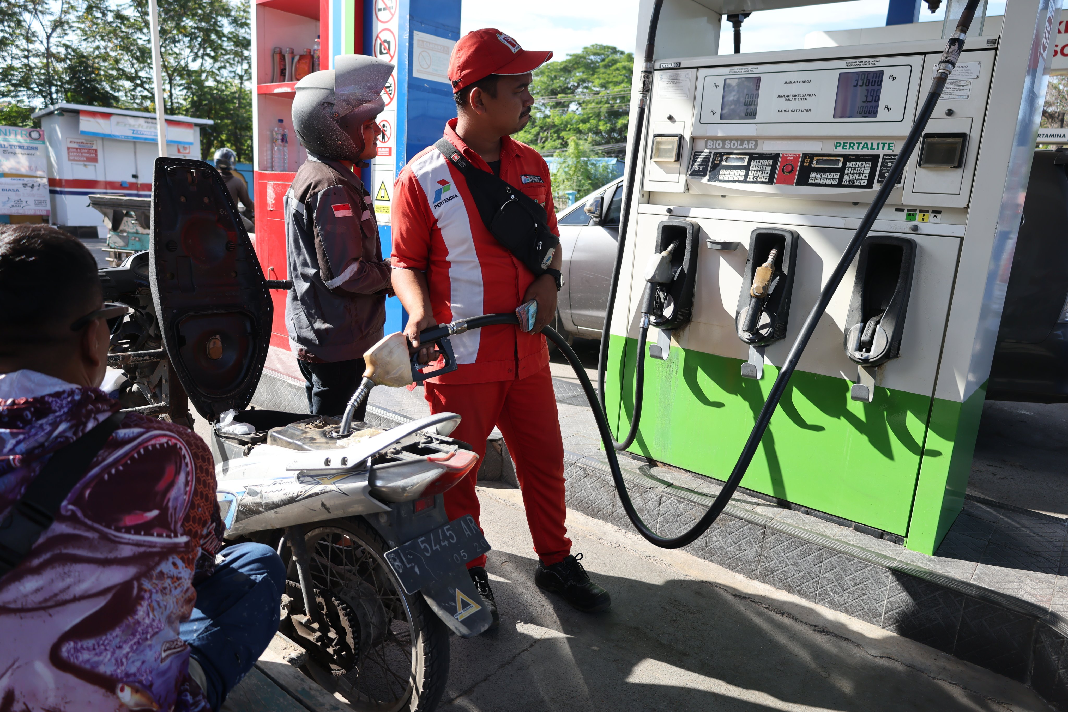 A worker refuels a motorcycle at a petrol station in Banda Aceh, Indonesia, on July 9. Photo: EPA