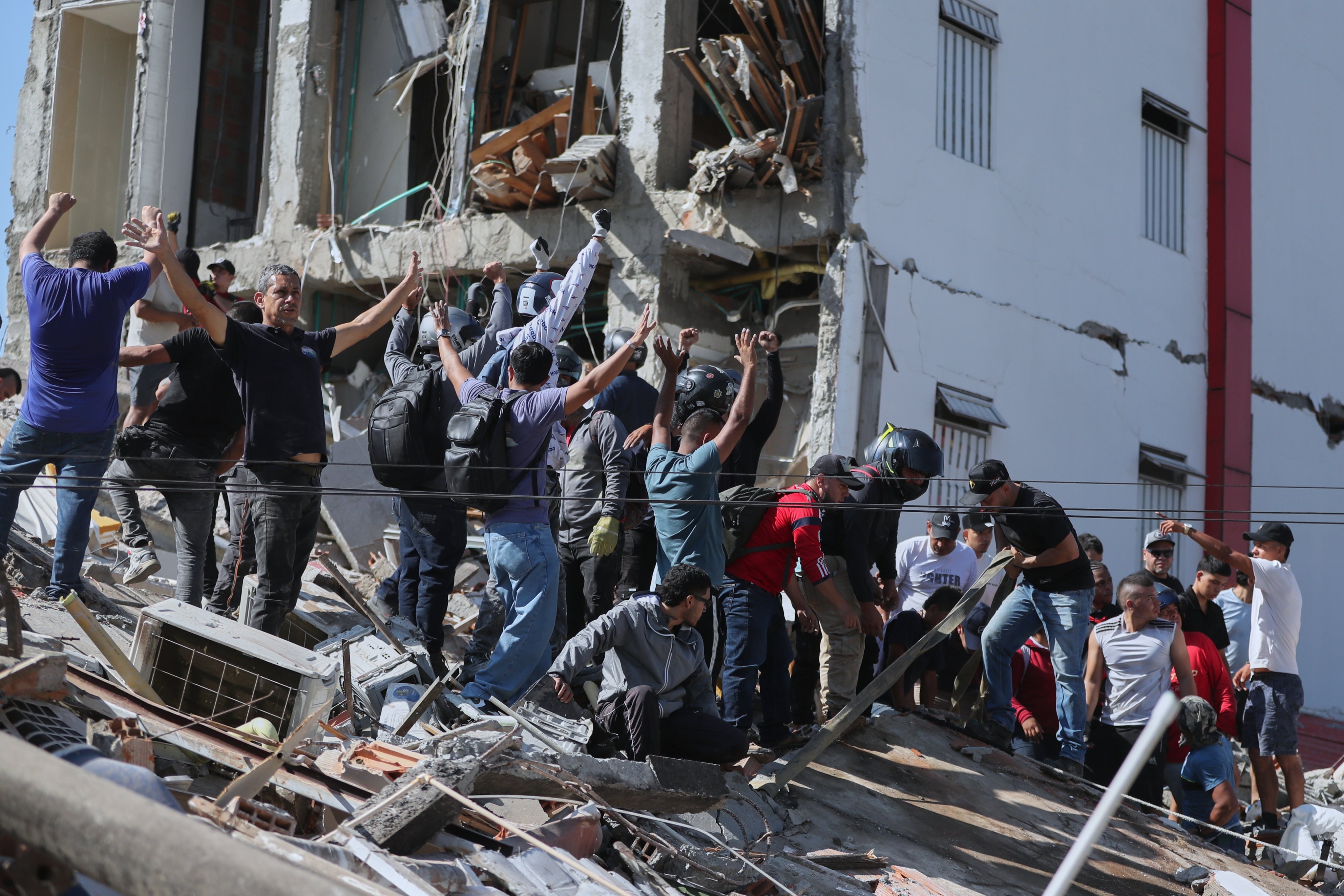 Residents and rescue workers search through the rubble of a collapsed building after an earthquake struck Cali, Colombia, on Monday. Photo: AP