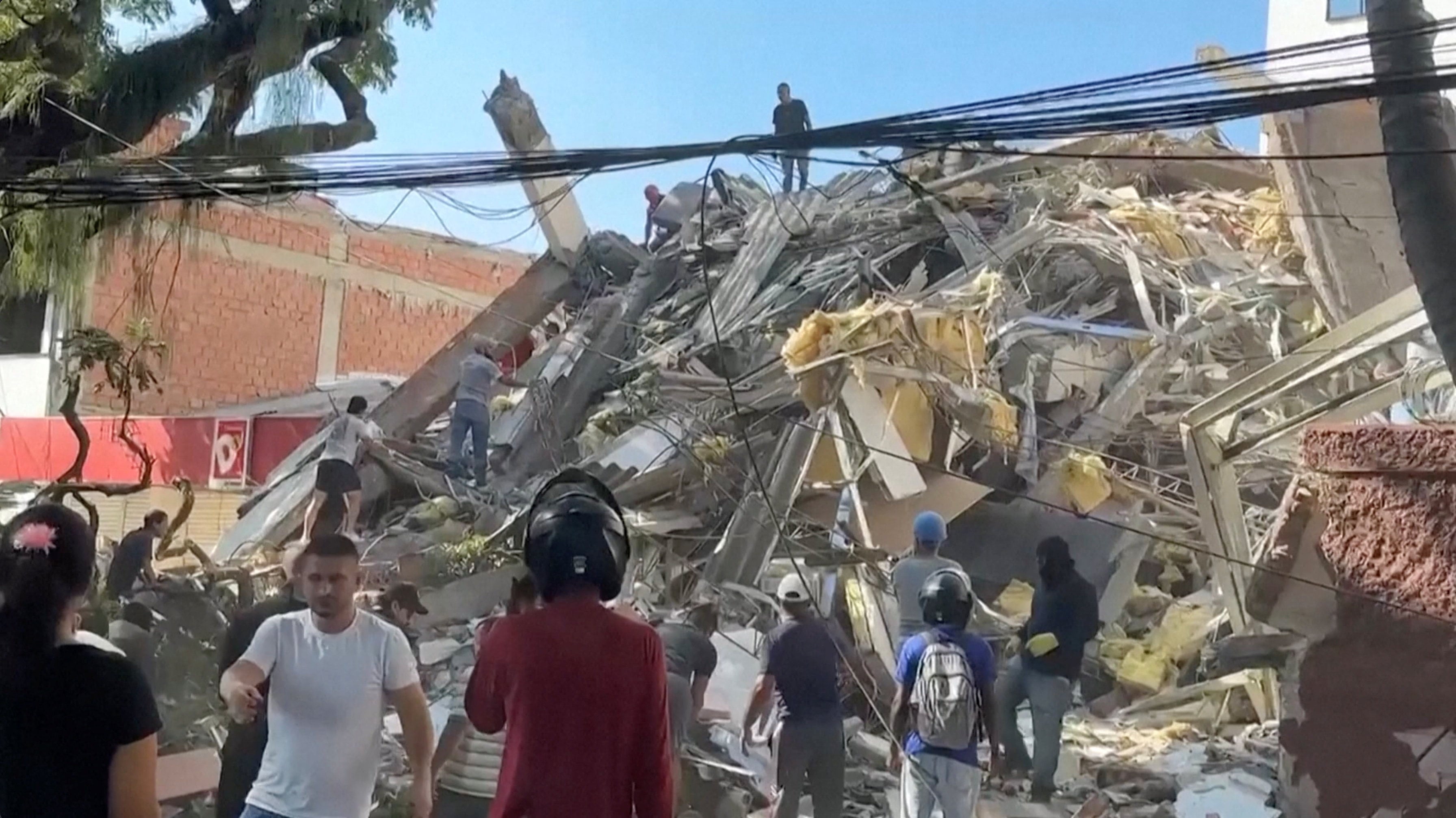 Rescue workers and residents stand around a collapsed building in the aftermath of an earthquake in Cali, Colombia, on Monday. Photo: Screengrab from video via Reuters