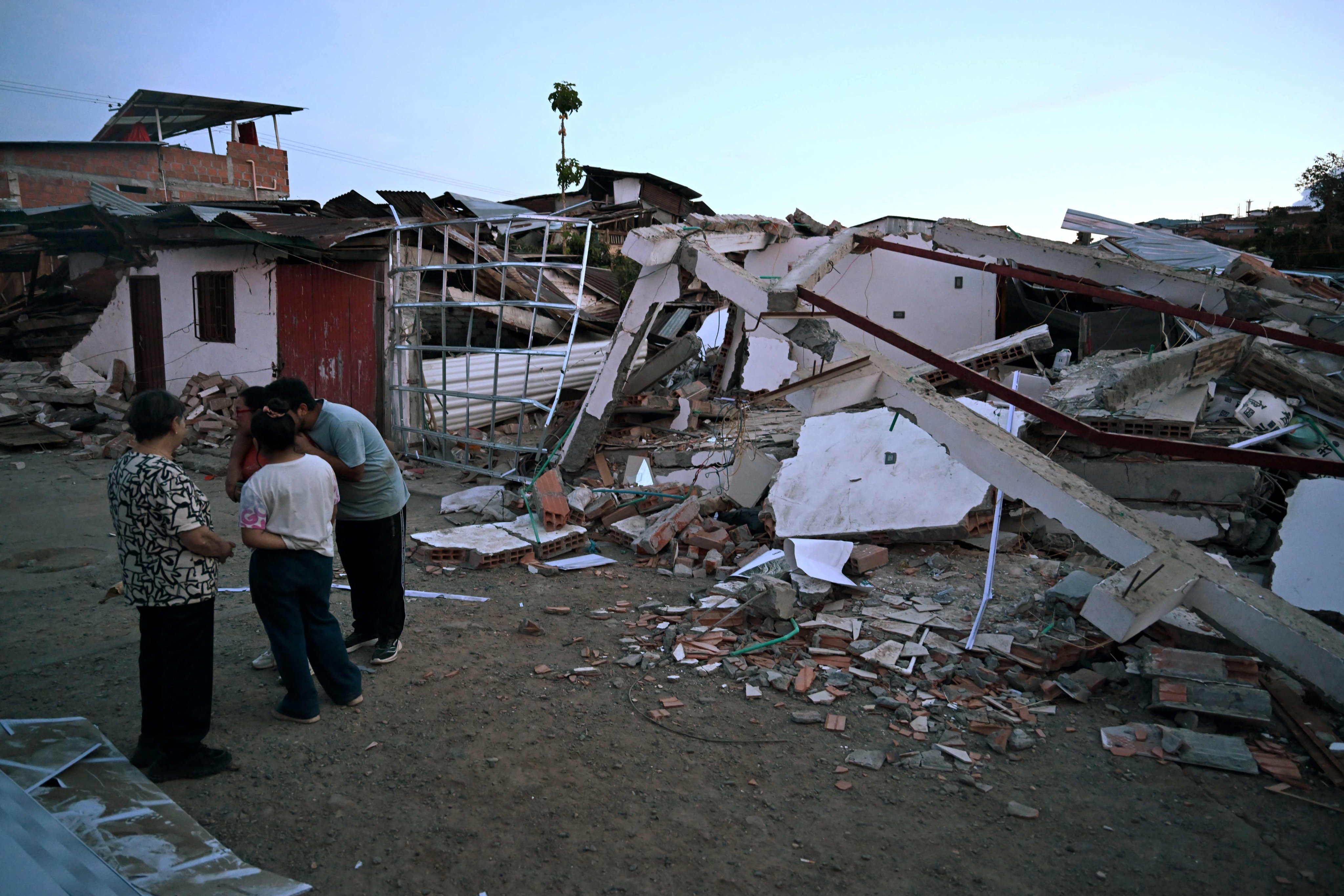 People gather in front of a destroyed house in El Cairo, Valle del Cauca, Colombia. Photo: AFP