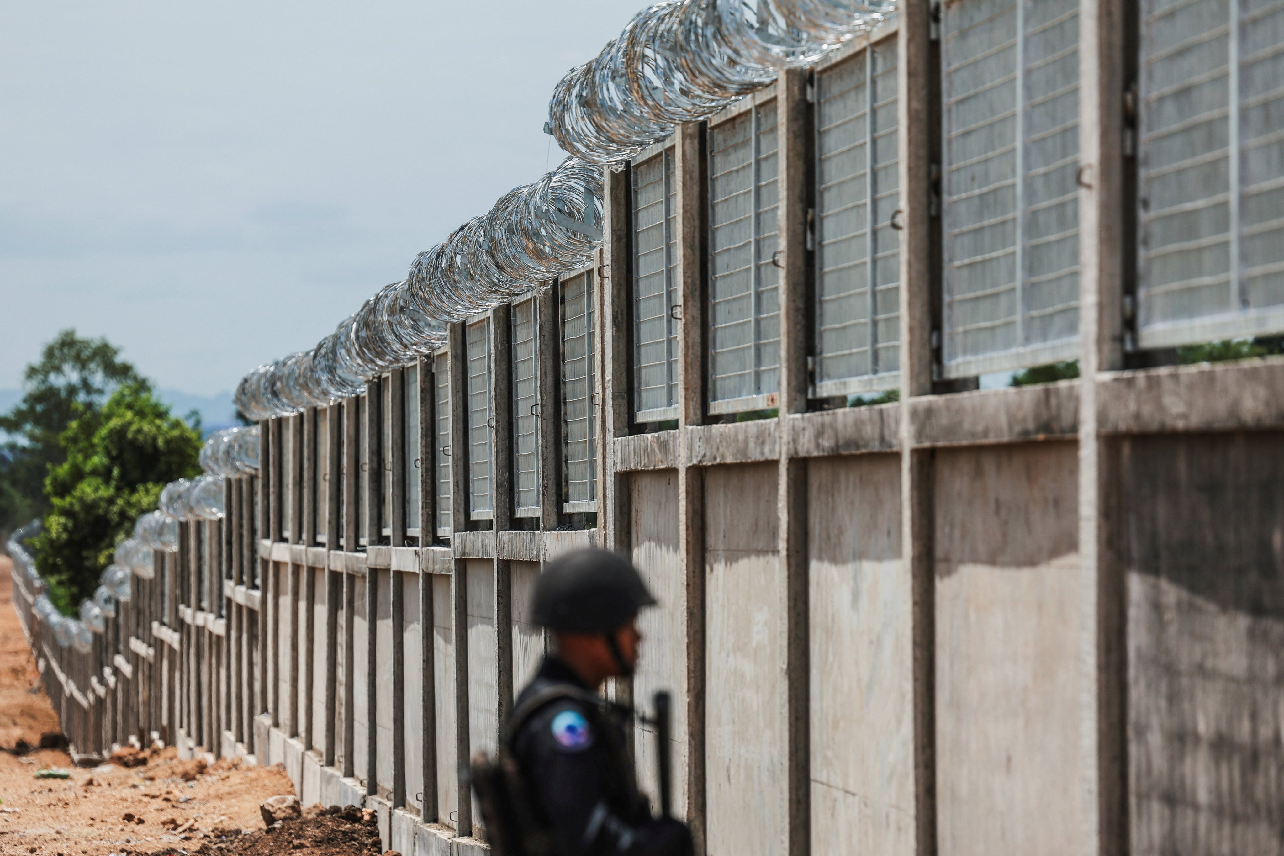 A Thai soldier stands guard as workers construct a section of the border fence between Thailand and Cambodia in Pong Nam Ron district, Chanthaburi province, in July. Photo: Reuters