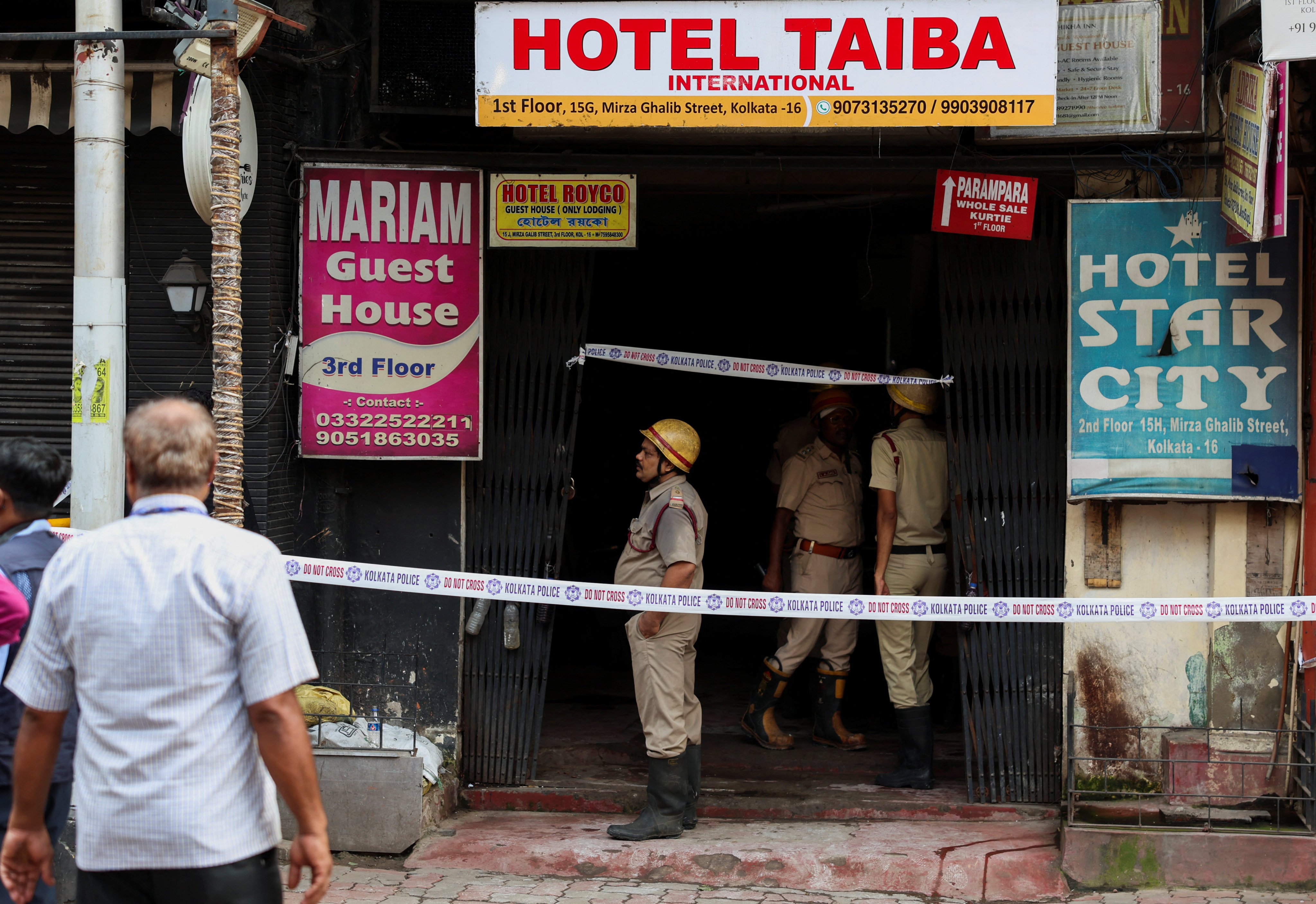 Firefighters stand at an entryway to a hotel where a fire broke out and killed several people, in Kolkata on Wednesday. Photo: Reuters