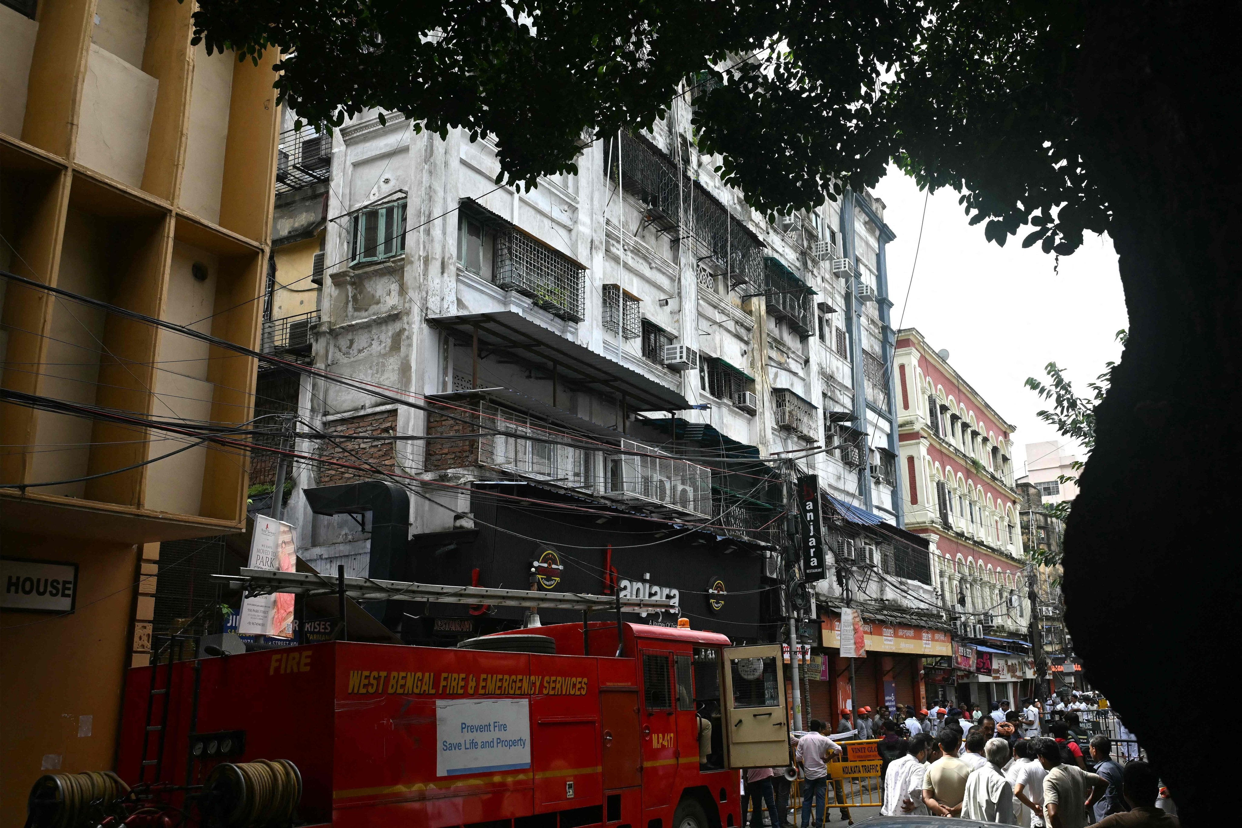Onlookers and fire personnel gather in the aftermath of a fire at a hotel in Kolkata on Wednesday. Photo: AFP